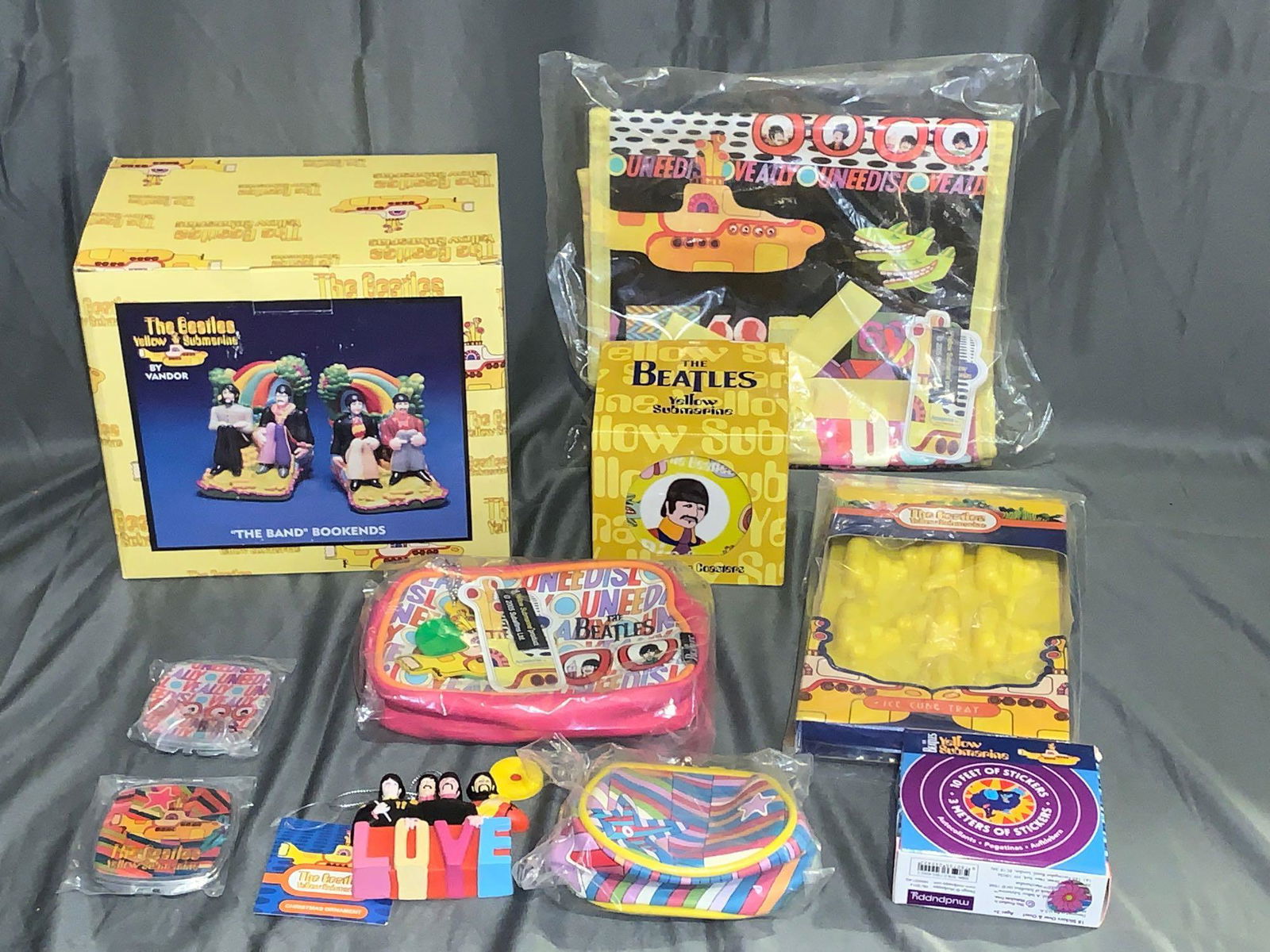 Grouping of Beatles Yellow Submarine Memorabilia: A grouping of Beatles "Yellow Submarine" memorabilia including a set of bookends, a jewelry bag, a set of coasters, ice cube trays, two different compacts, a Kurt S. Adler ornament, two purses and a b