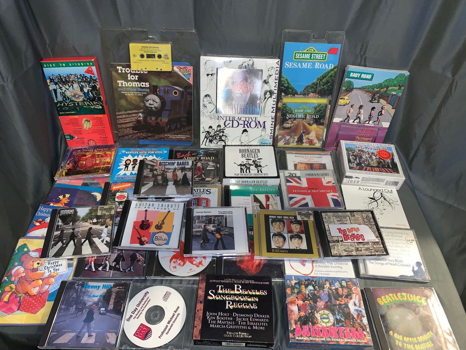 37 Beatles-related CDs and Cassettes: A lot of 37 Beatles-related CDs and cassettes, including mostly Beatles covers, but also includes an Al Hirschfeld CD-ROM, a Thomas the Tank Train book and cassette (narrated by Ringo Starr), an Israe
