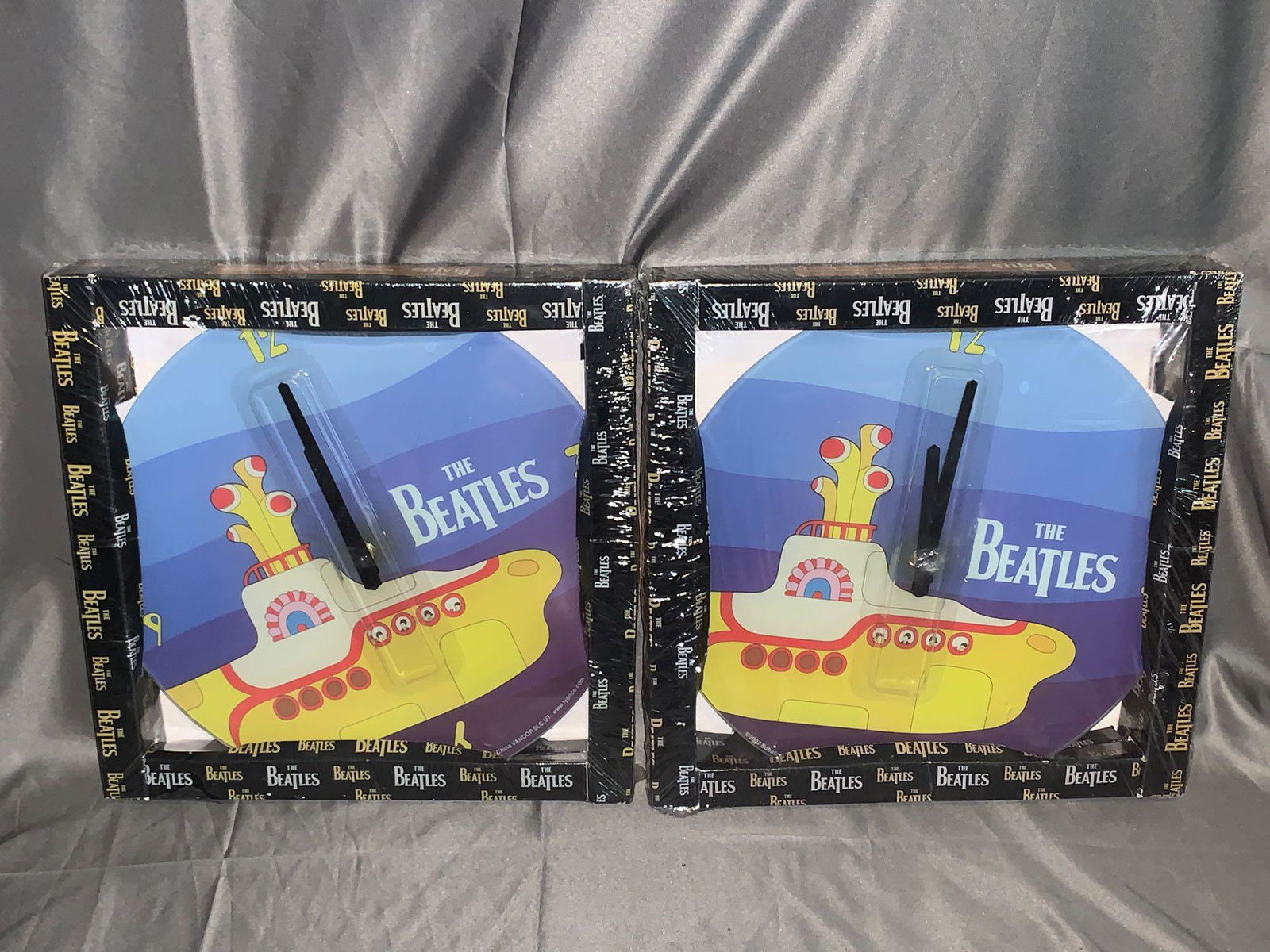 Two Beatles Yellow Submarine Wall Clocks: A lot of two Beatles Yellow Submarine wall clocks in original packaging, by Vandor. Each box: apx. 12in square.