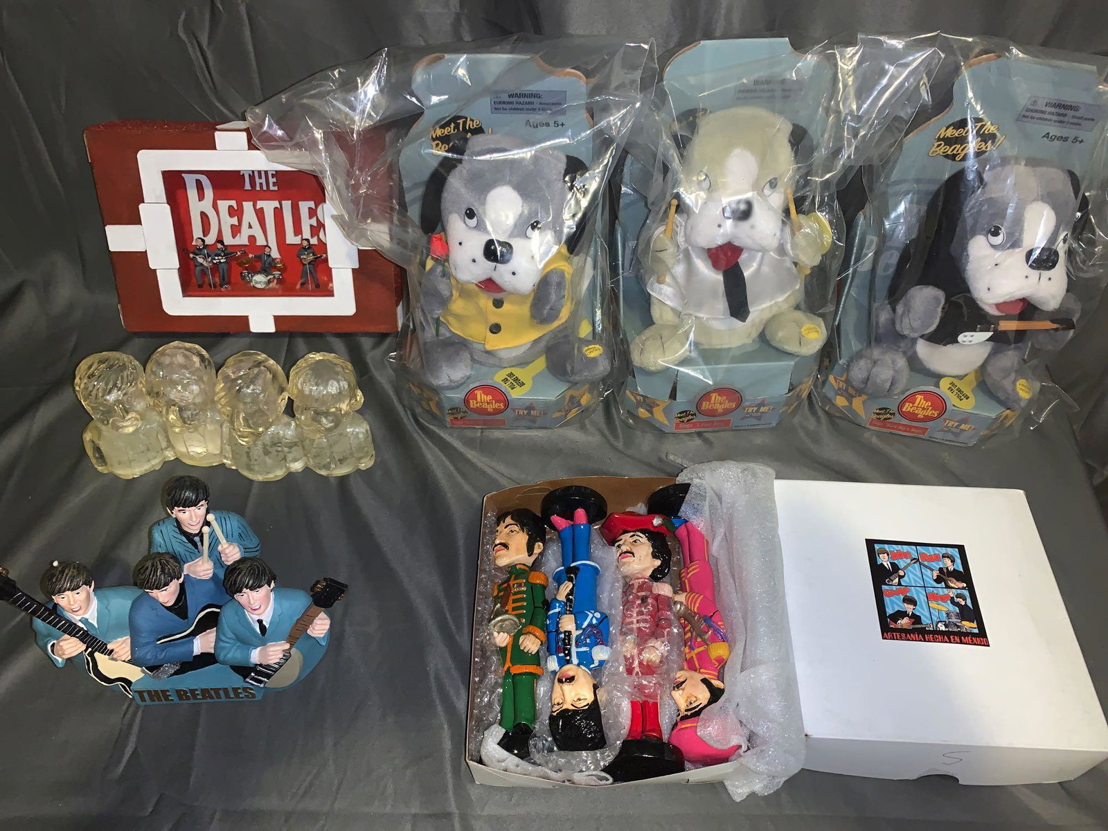Grouping of Beatles Memorabilia: A grouping of Beatles memorabilia, including three "Meet the Beagles" dogs, a set of four Mexican paste Sgt Pepper's figures, a Beatles bust, a Beatles bank and a Beatles shadowbox signed by the artis