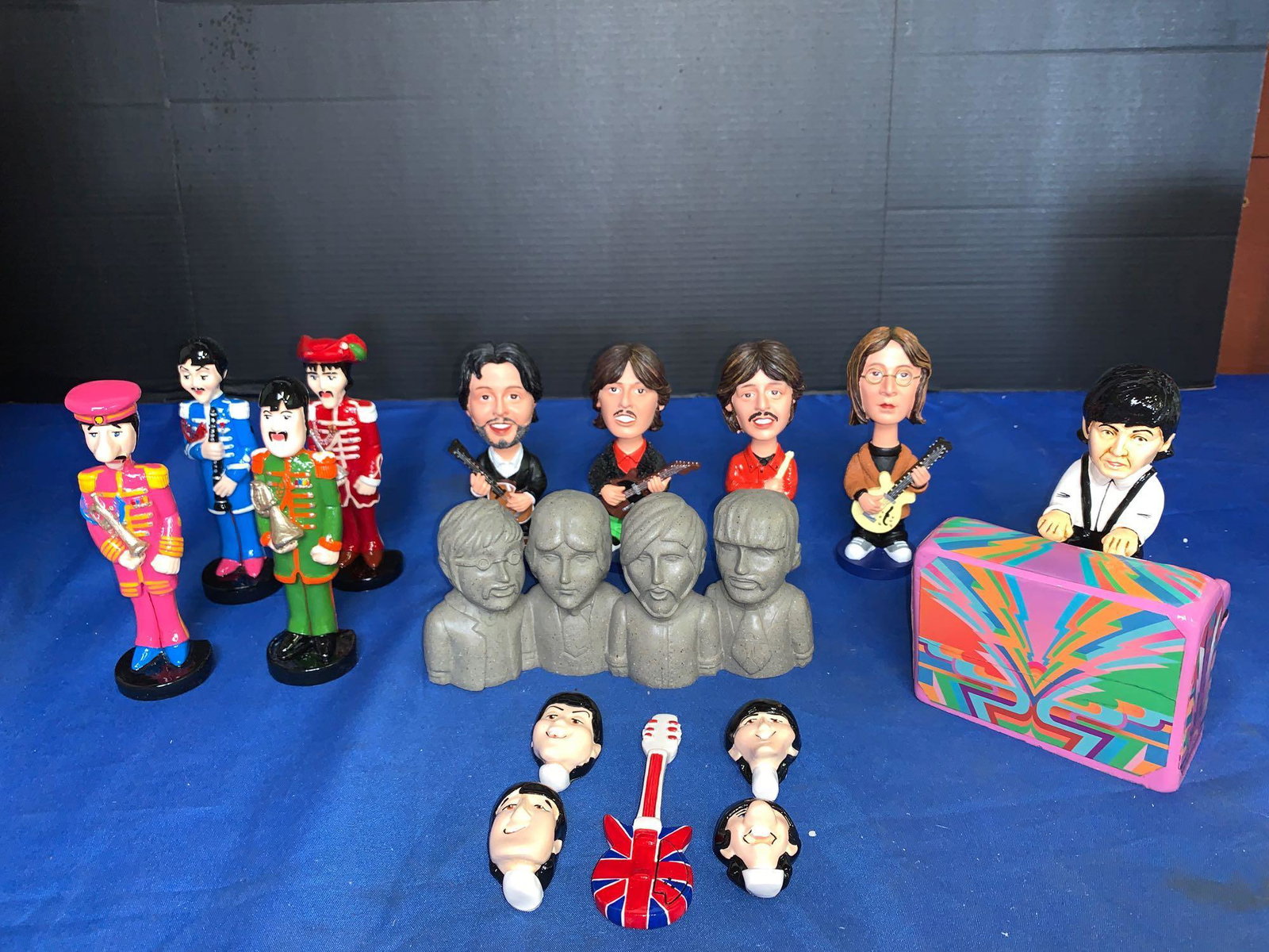 Grouping of Beatles Figures, Nodders & More: A grouping of Beatles figures, nodders, and more, including a set of four nodders, a set of four Sgt Pepper's figurines, a set of five magnets, a Beatles bank and a Paul McCartney figure standing behi