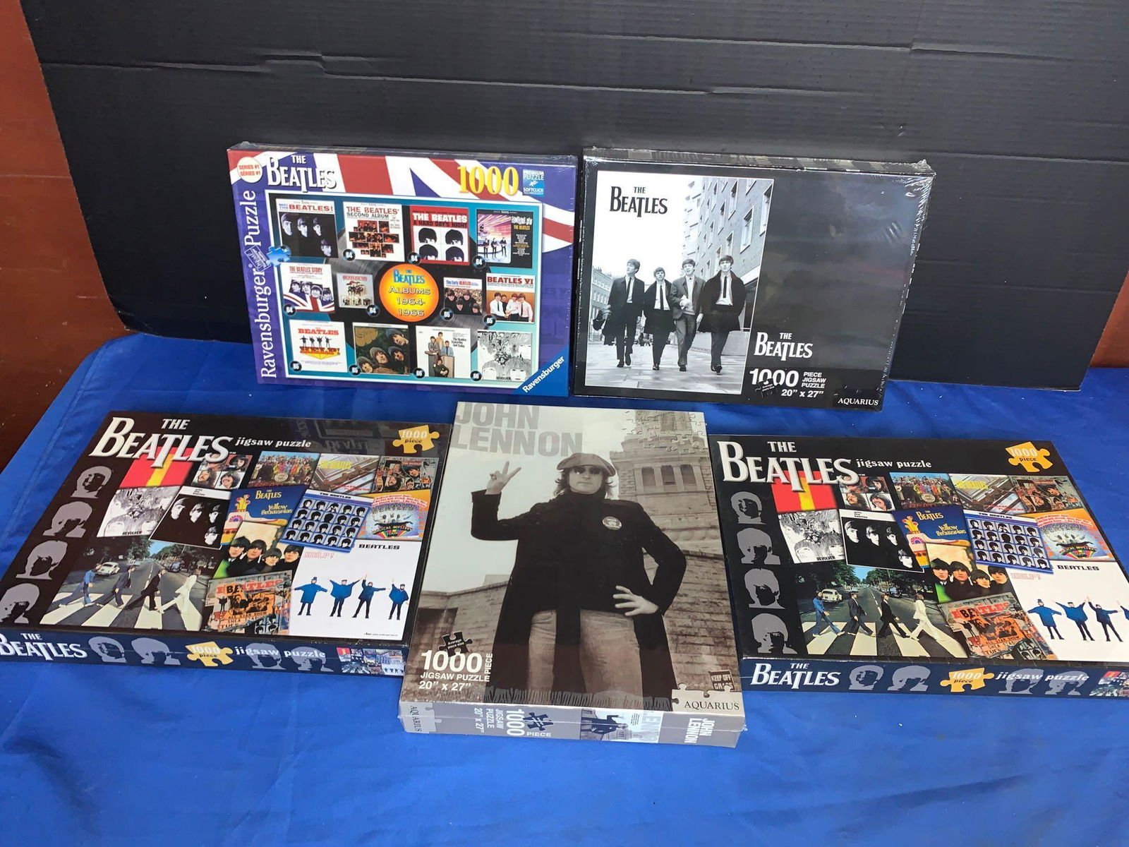 Grouping of Five Beatles Puzzles: A lot of five Beatles puzzles including a Ravensburger puzzle and a John Lennon puzzle.