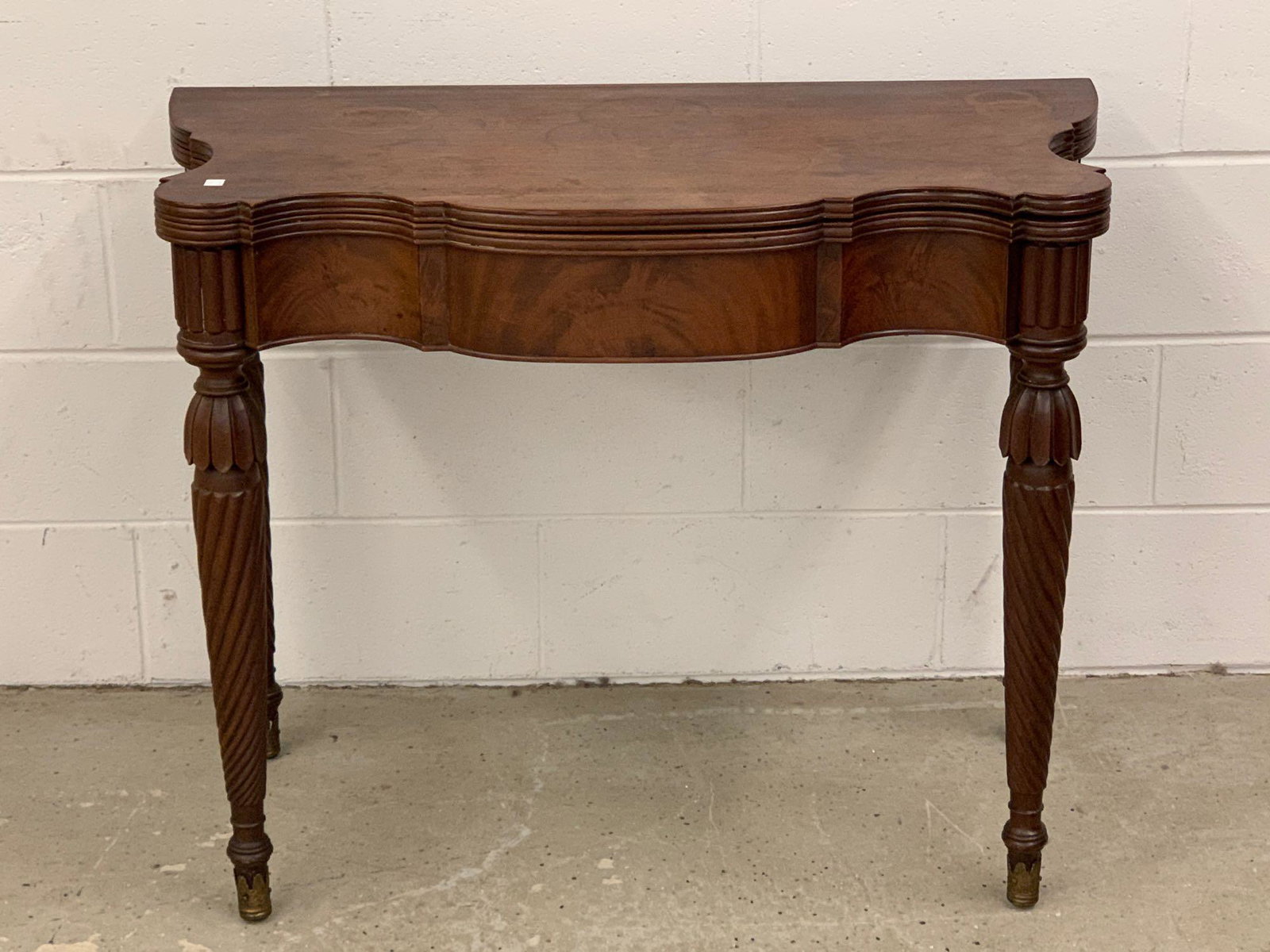 American Federal Mahogany Card Table: An American Federal mahogany games table having a flip top over nicely carved and twisted legs, ending in brass capped feet. Closed: 29in tall x 36-1/2in wide x 18in deep.