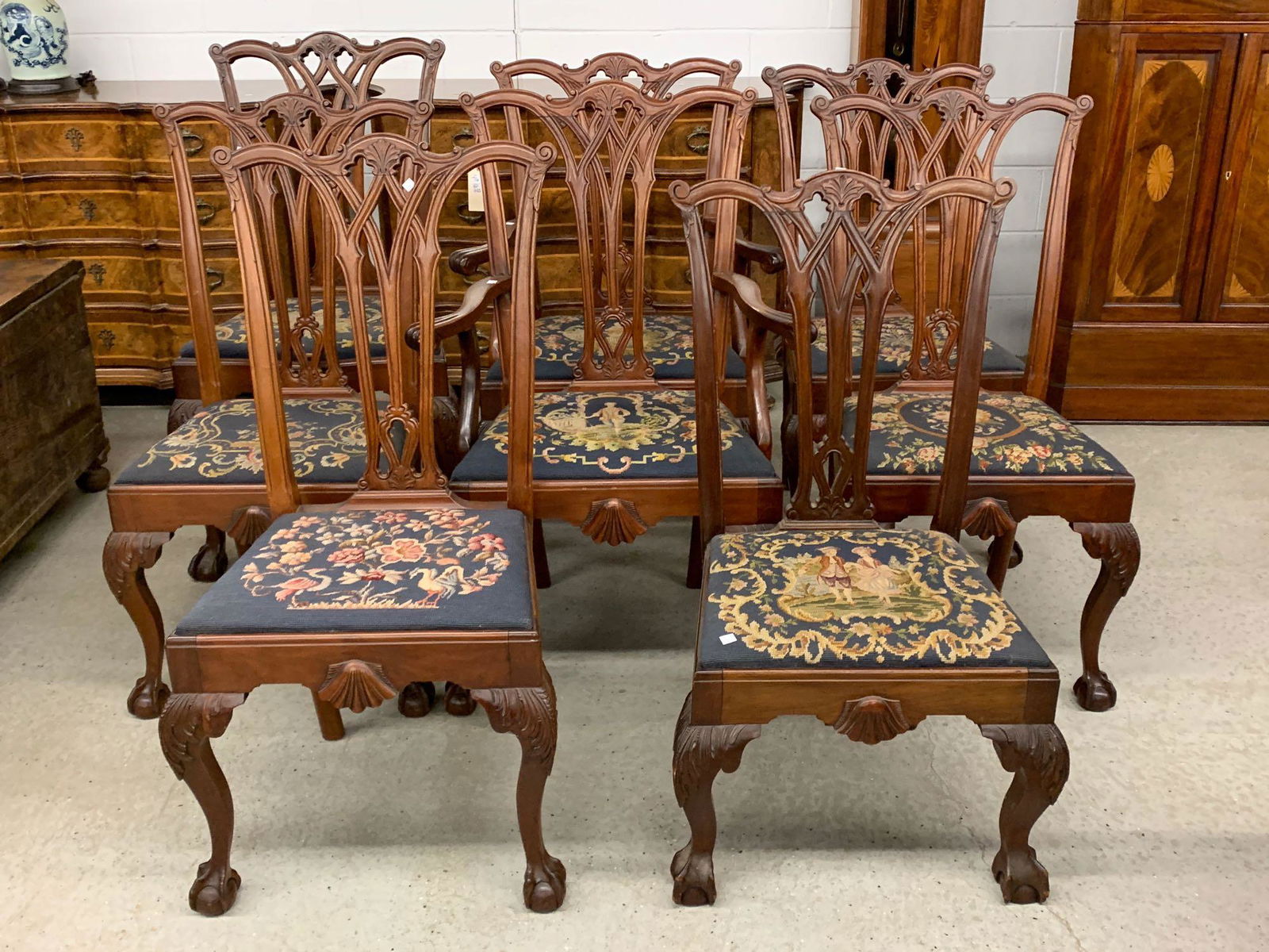 Eight Chippendale-style Mahogany Dining Chairs: A set of eight near matching Chippendale-style carved mahogany dining chairs with pierced backs, shell carved aprons, acanthus knees and ball and claw feet. Comprised of two armchairs and six side cha