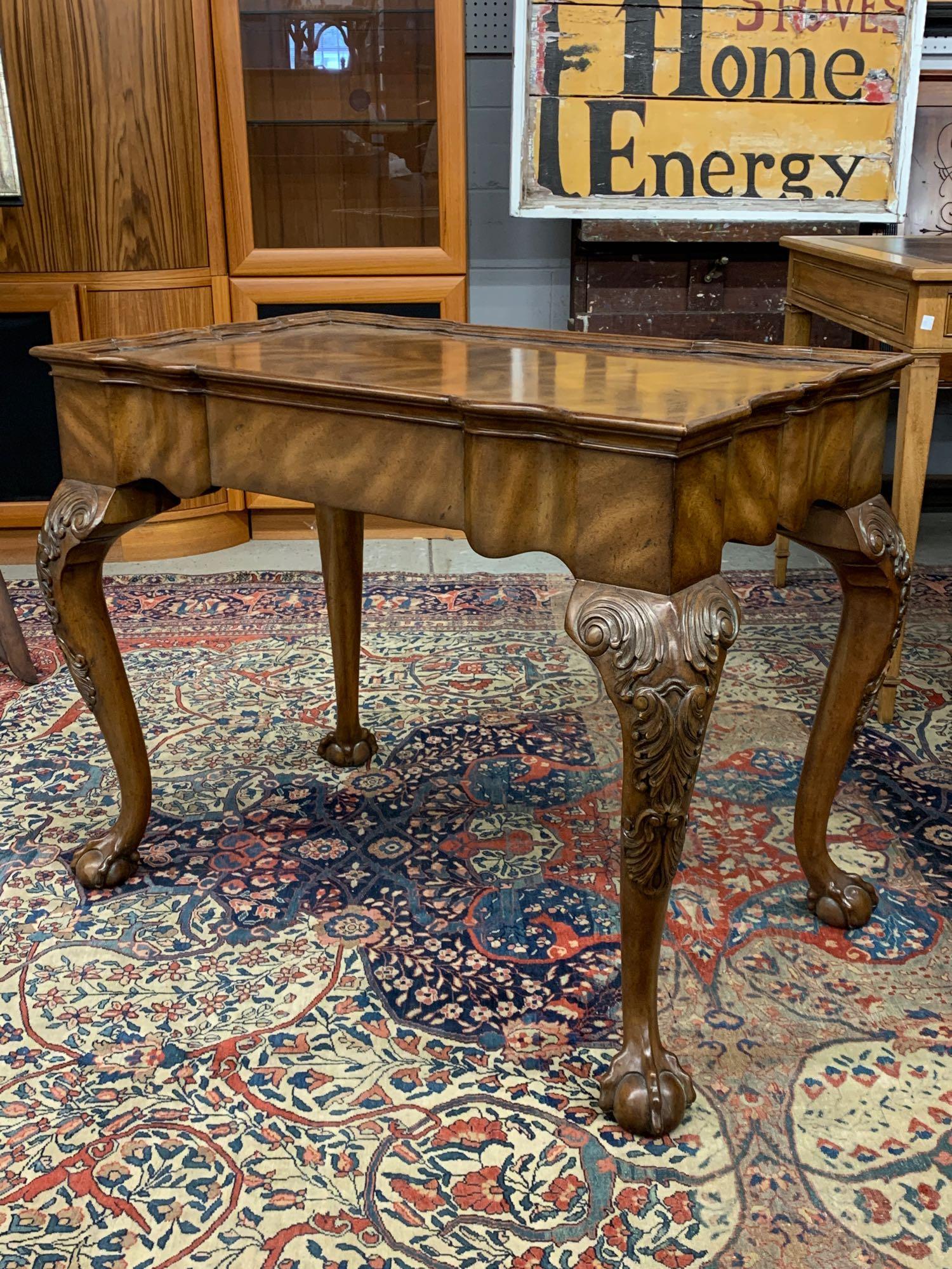 Maitland Smith Georgian-style Tea Table: A Maitland Smith Georgian-style mahogany tea table having a shaped rectangular top over carved knees and ball and claw feet. 27-1/2in tall x 34in wide x 20in deep.