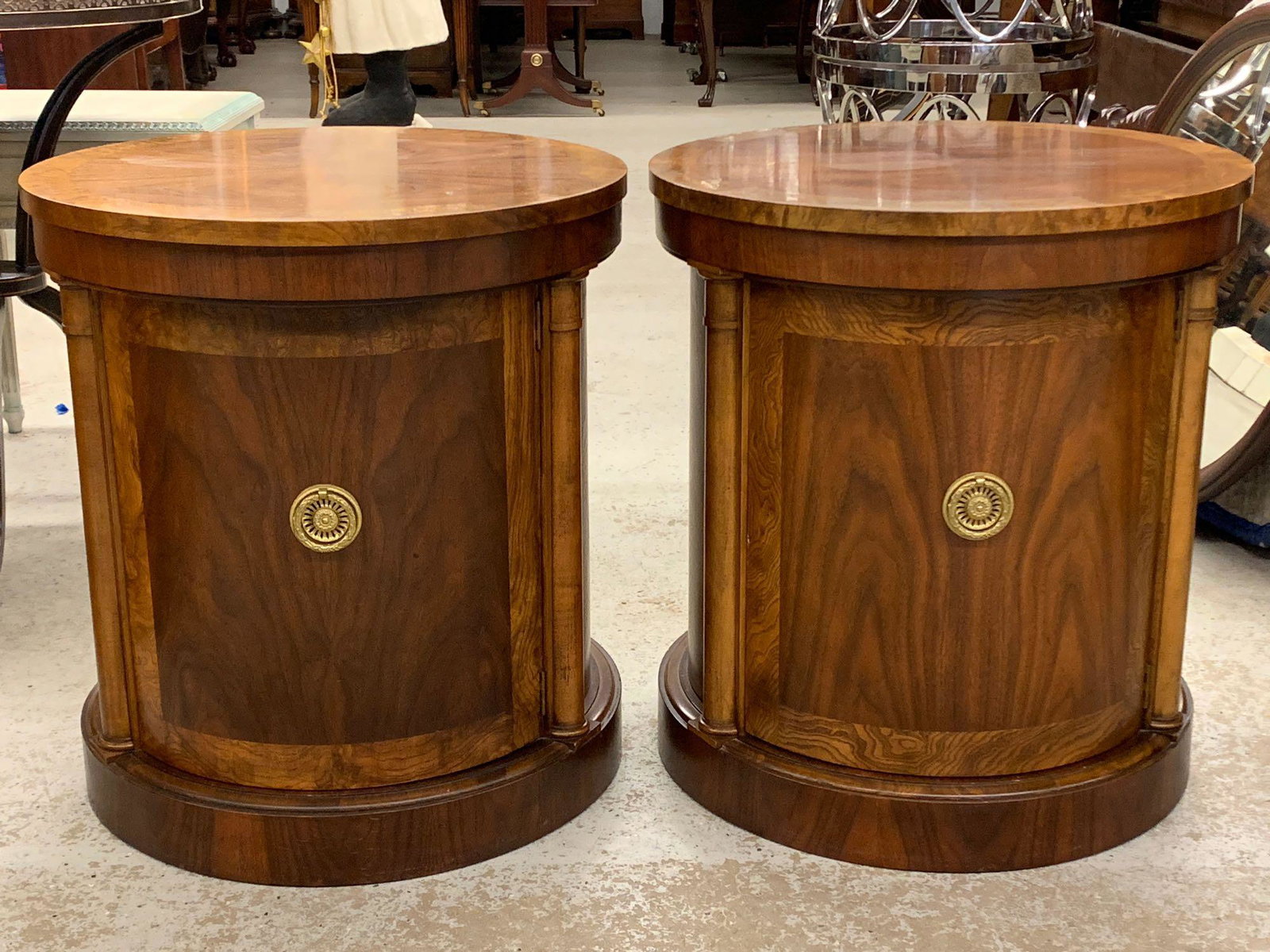 Pair of Baker Cabinet Drum Tables: A pair of Baker mahogany drum table cabinets, each with circular banded tops over single door cabinet bases. Each is 24in tall x 22in diameter.