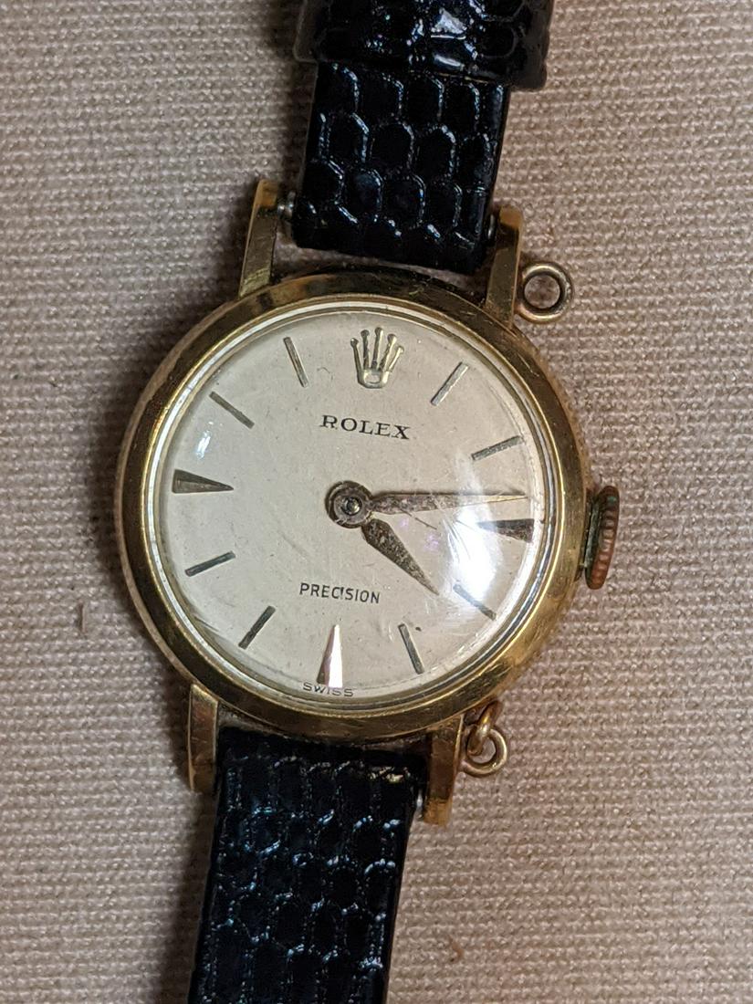 Lady's 18K Gold Rolex Wristwatch: A lady's Rolex Precision wristwatch with 18K yellow gold case, leather band (replaced), and round case. Case #9488. 17 jewel.