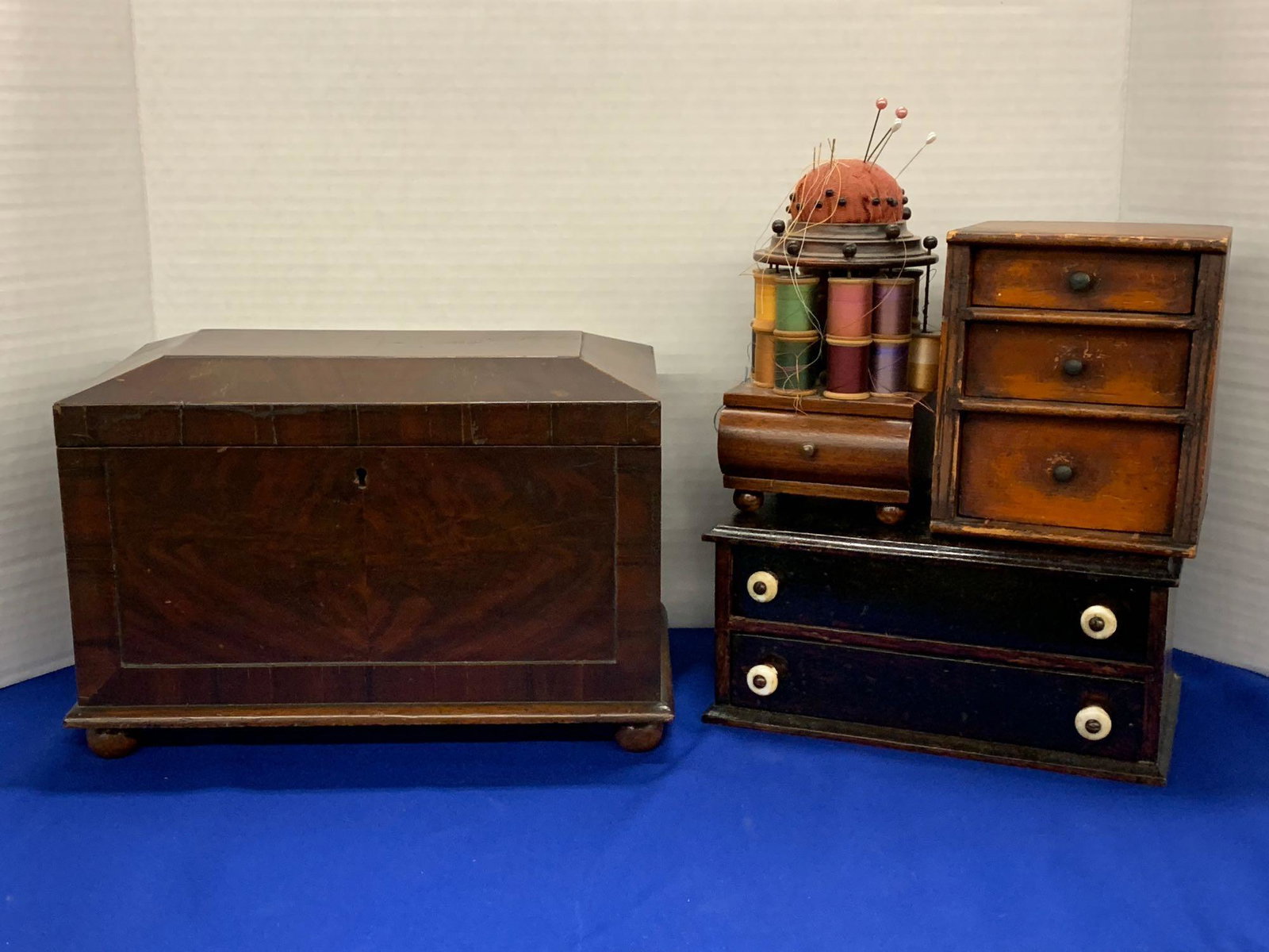 Antique Sewing Box Grouping: A four-piece antique sewing grouping to include a mahogany box with mirror-lined lid, two small cabinets with drawers, and a spool caddy. Largest box: 8-1/4 in tall x 12-3/4 in wide x 7-1/2 in deep.