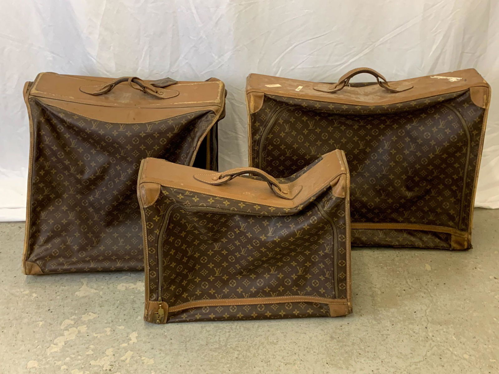 Three Vintage TFLC for Louis Vuitton Luggage Bags: A grouping of three Louis Vuitton luggage bags, all of which appear to have been produced by The French Luggage Company under special license. Largest: 22 in tall x 28 in wide x 9 in deep.