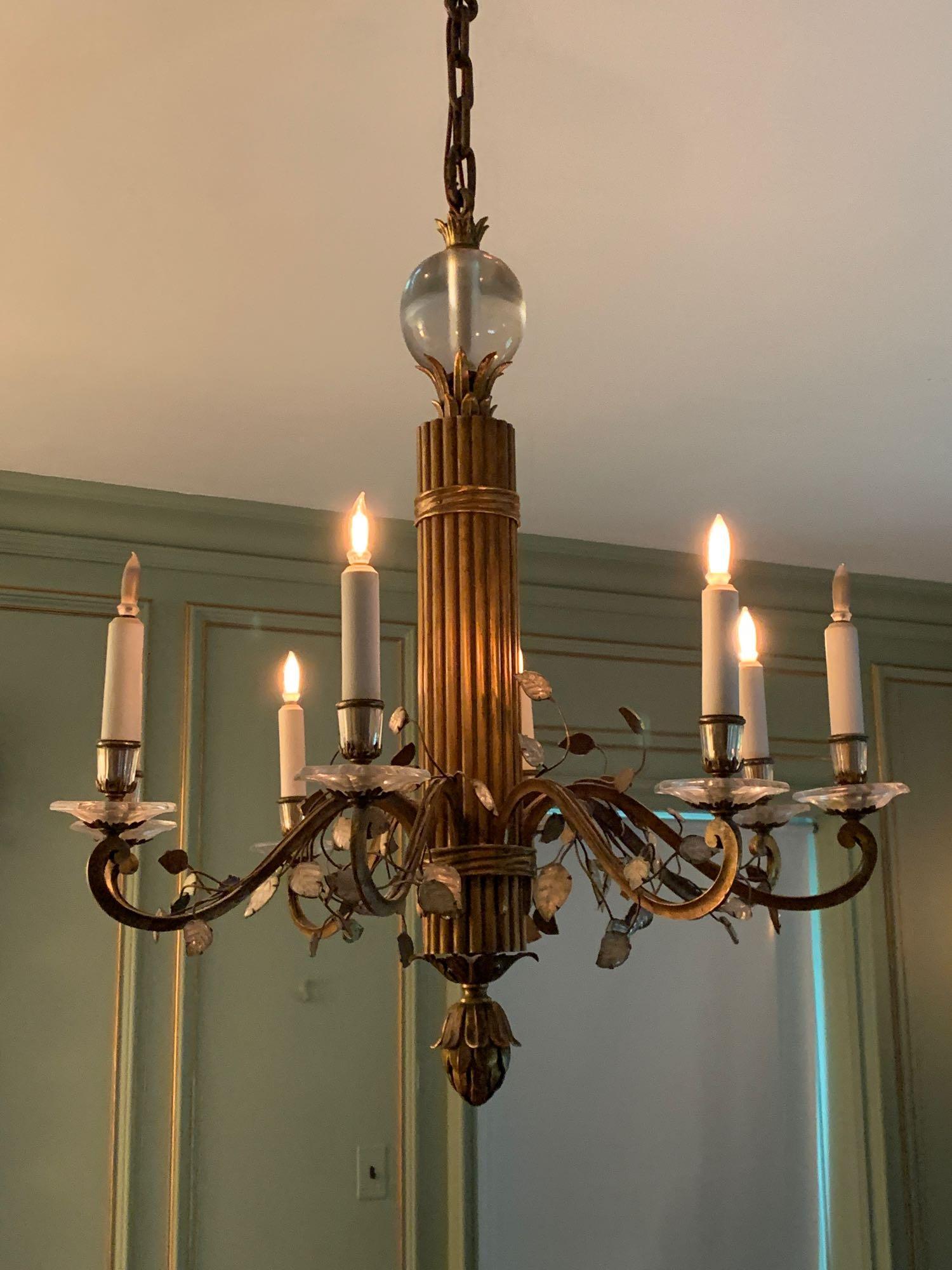 Bagues-style Gilt Metal and Crystal Chandelier: A chandelier by or in the style of Maison Bagues, having a glass-ball top over a gilt metal-wrapped rod-form shaft and eight candle arms with crystal leaf designs. Unmarked. 32 in tall x 29 in diamete