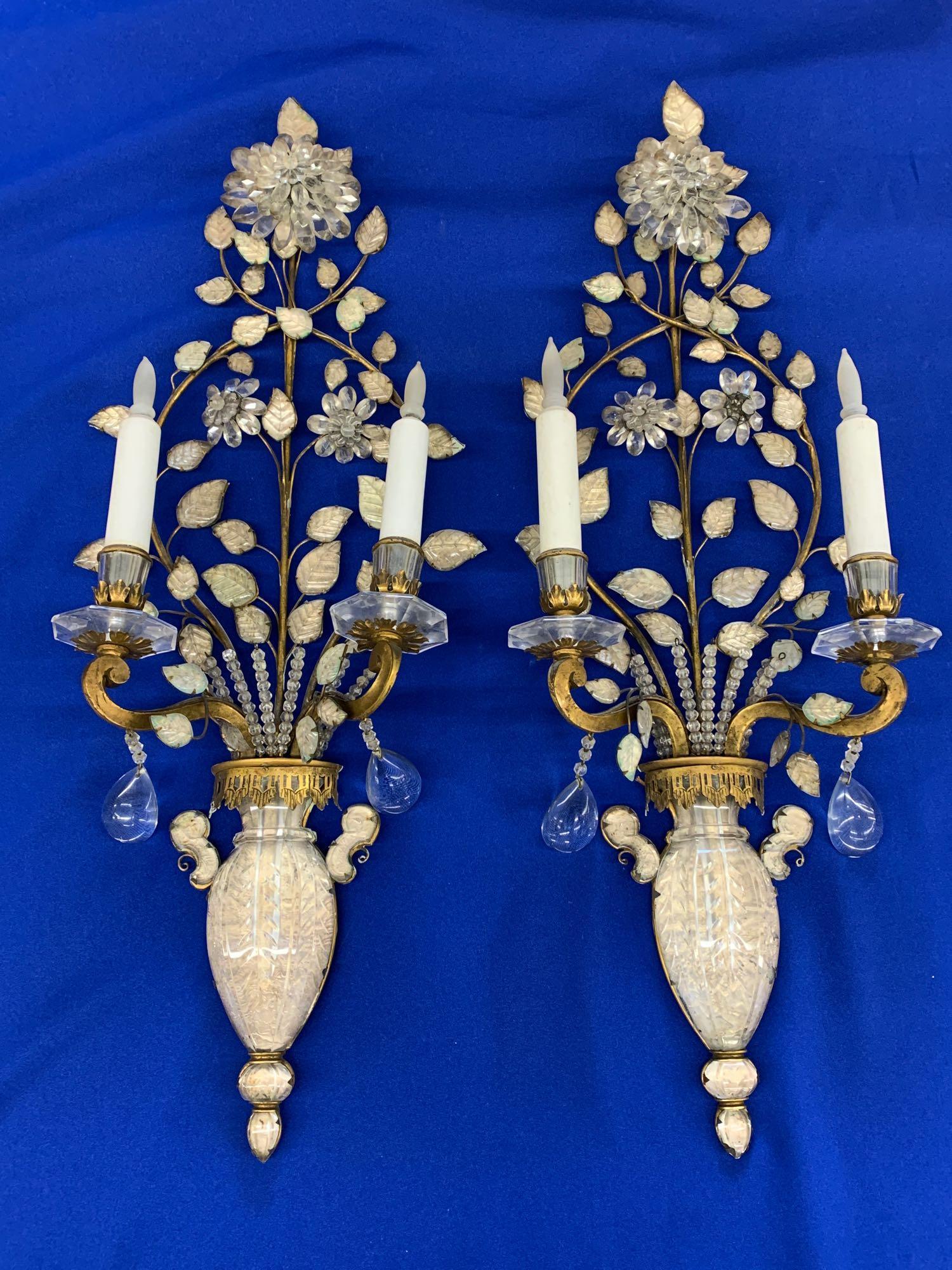Pair of Bagues-style Gilt Metal & Crystal Sconces: A pair of Masion Bagues-style wall sconces having gilt metal frames, foliate designed crystals, and two electrified candle arms. Each is 28-1/2 in x 10-3/4 in.