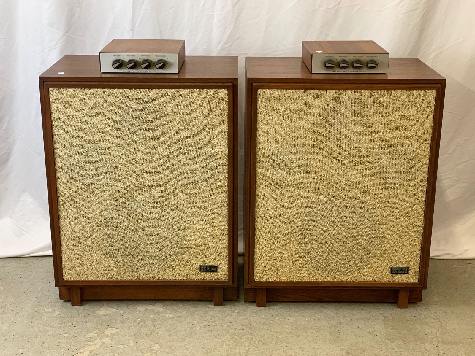 Pair of KLH Model Twelve Speakers: A pair of midcentury modern walnut-case KLH model twelve speakers with contour controls. Each is 29 in tall x 22-1/4 in wide x 15 in deep.