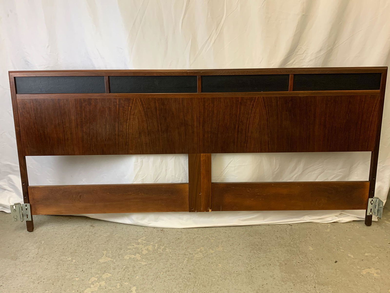 American Modern Walnut Headboard and Mirror: An American midcentury modern walnut king-size headboard with black leather panels, together with a matching mirror with ebonzied trim. Headboard: 35-1/2 in tall x 77 in wide. Mirror: 32 in tall x 48