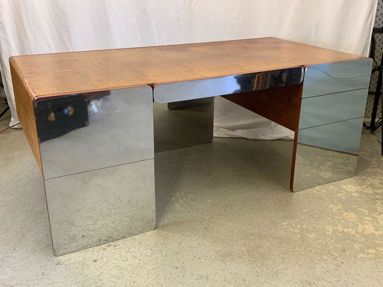 Modernist Mirrored Chrome Executive Desk: A Paul Evans-style 1970s modern executive desk by Xception, having a figured oak case and mirrored facings. 29 in tall x 72 in wide x 36 in deep.