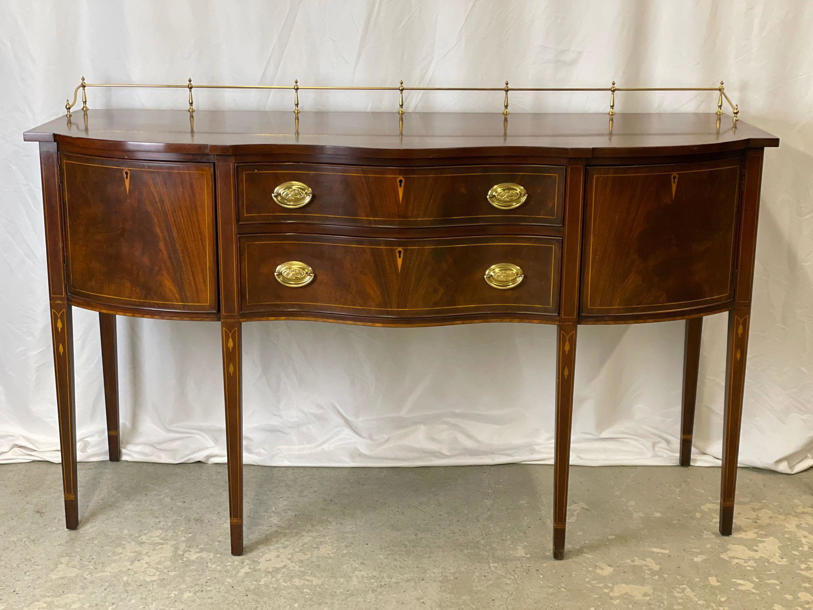 Henkel Harris Federal-style Mahogany Sideboard: A Henkel Harris Federal-style inlaid mahogany sideboard with brass gallery rail and two drawers flanked by cupboard doors. 42in tall x 66in wide x 25in deep.
