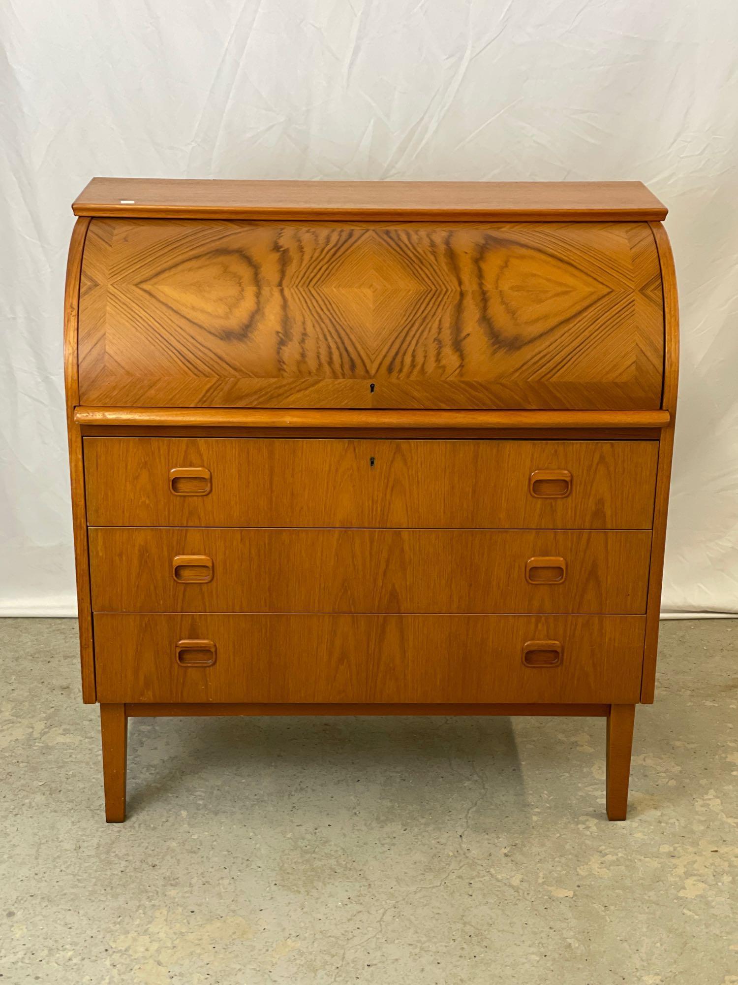 Danish Modern Teak Cylinder Desk: A Danish modern teak cylinder desk with fitted interior and three drawers, raised on tapering legs. With key. 38in tall x 35-1/2in wide x 18-1/2in deep.