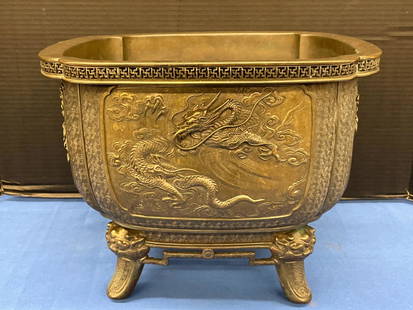 Japanese Square Bronze Planter: A Japanese square, bronze planter with sides decorated in relief with a dragon, turtle, phoenix, and lion, raised on mask-form feet and signed on base. 10in tall x 13-1/4in wide x 13-1/4in deep.