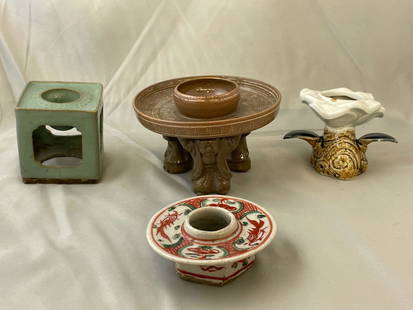 Four Japanese Sake Cup Stands: A grouping of four Japanese porcelain haidai or sake cup stands to include a figural example (signed), and one of lotus form. Tallest: 3-1/4in tall x 4-3/4in diameter.