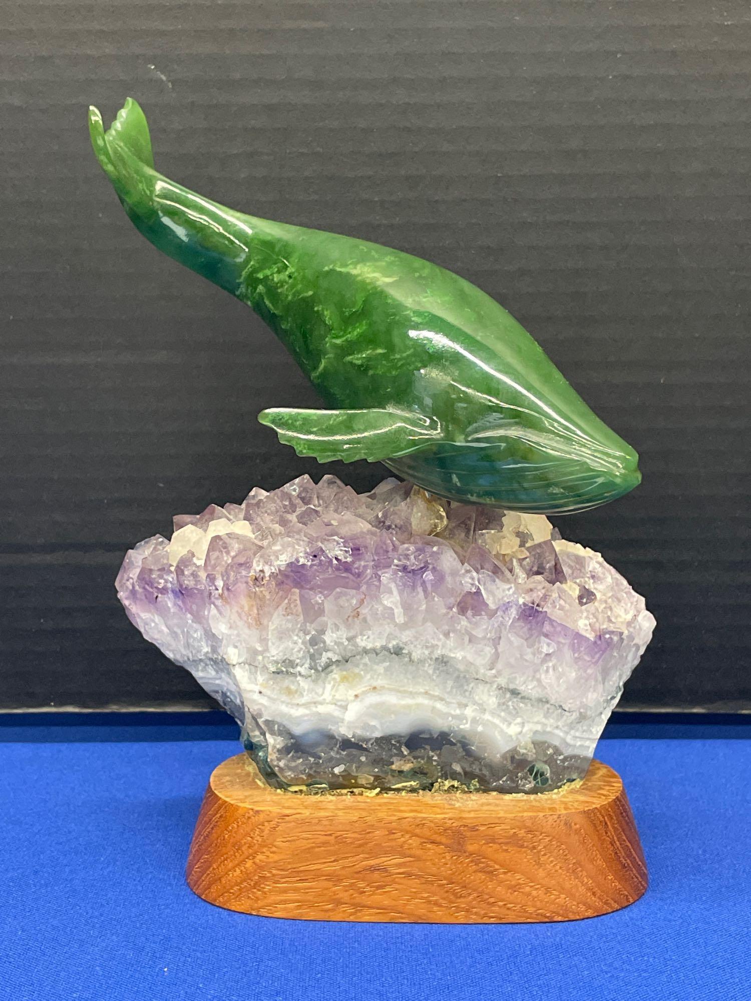 Lyle Sopel. Nephrite Jade Carving, Humpback Whale: Lyle Sopel (British Columbia, 1951-). A nephrite jade carving of a humpback whale on an amethyst stone base. Signed, numbered 881, and dated 84. 7-1/4in tall x 5-1/8in wide.