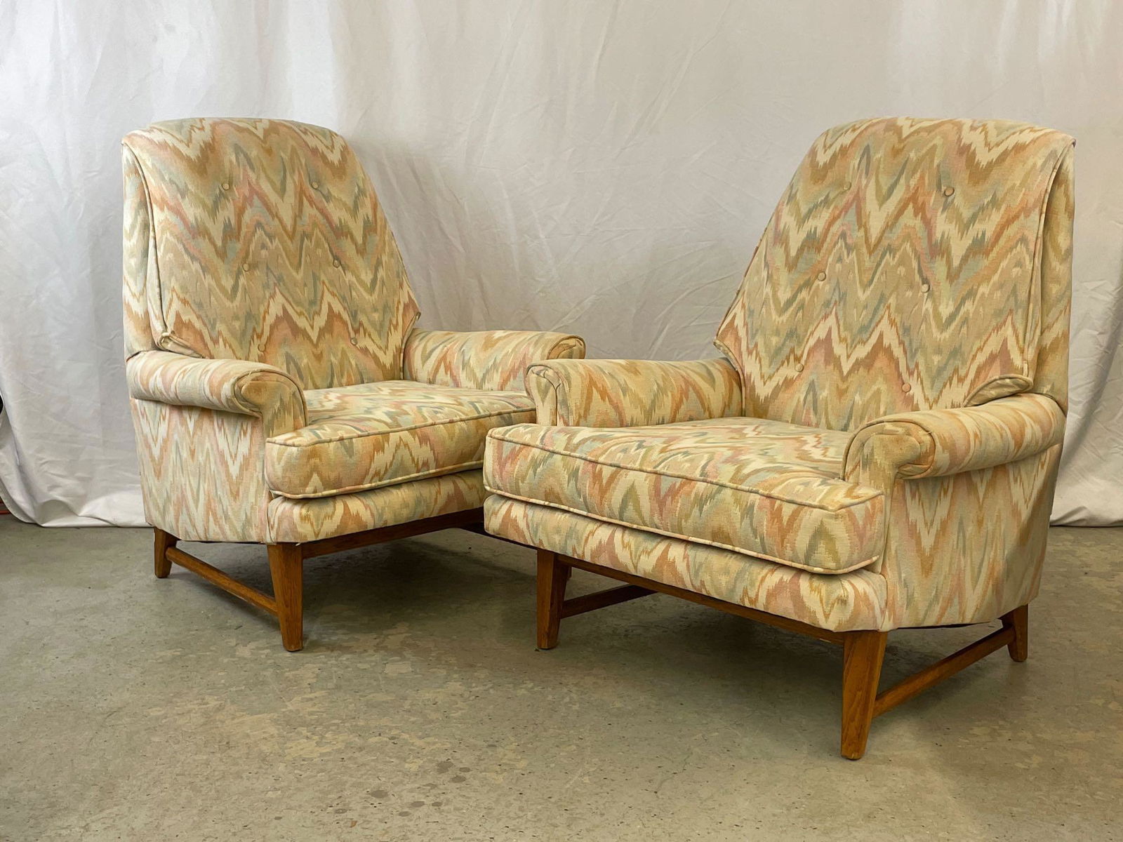 Pair of Midcentury Modern Lounge Chairs: A pair of midcentury modern lounge chairs in the style of Adrian Pearsall, having angled frames and flame stitch upholstery. Unmarked. 36in tall x 32in wide x 31in deep. Seat height: 16in.