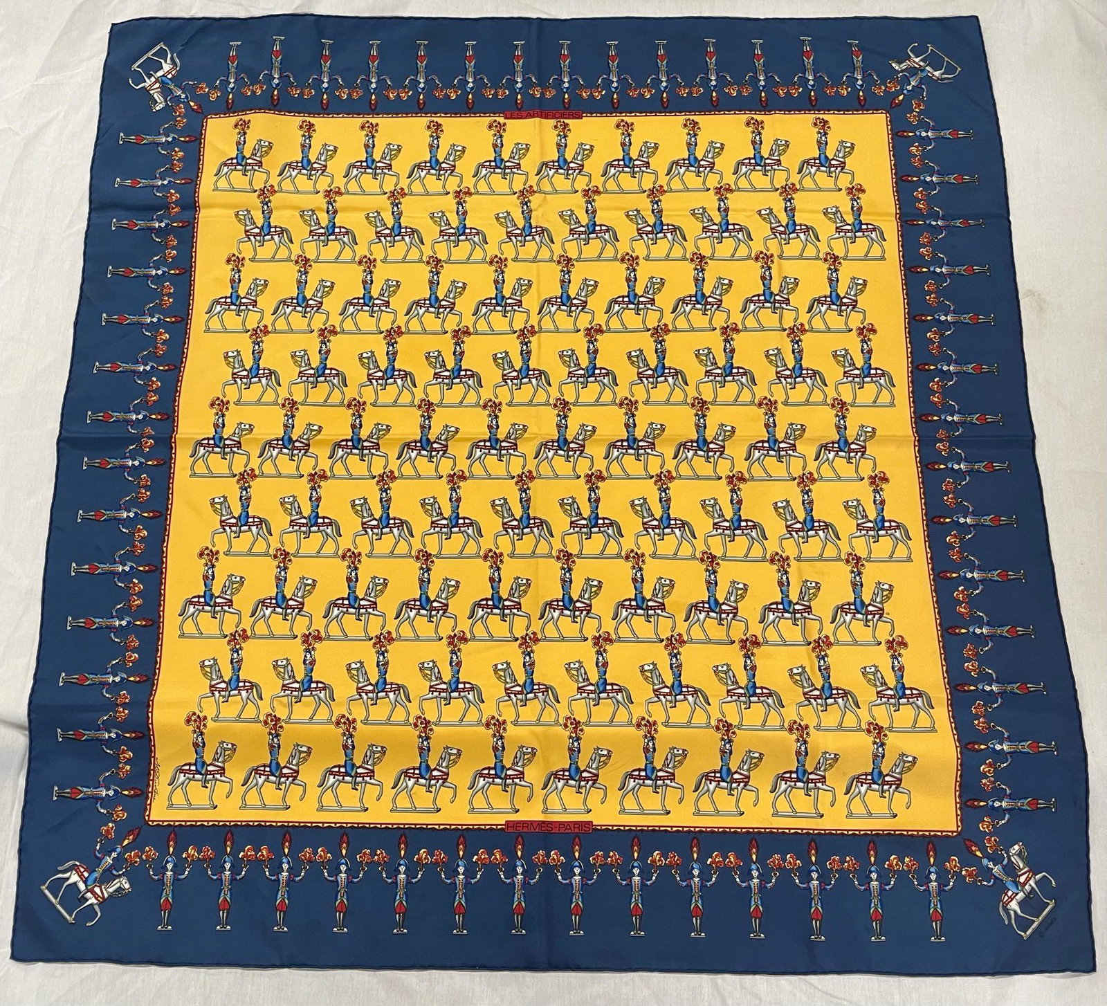 HermÃ¨s Silk Scarf: Les Artificiers: A woman's navy and gold HermÃ¨s silk scarf in the "Les Artificiers" design by Michel Duchene, circa 1987. Hand-rolled edges. 35 x 35in.