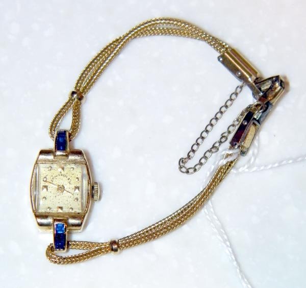 Lady's wristwatch.: JE Caldwell & Co, Concord Watch Co, Swiss. 14K yg case with six channel-set square cut blue sapphires and gold-filled rope band. 17 Jewels, #334 S. 7.2dwt.