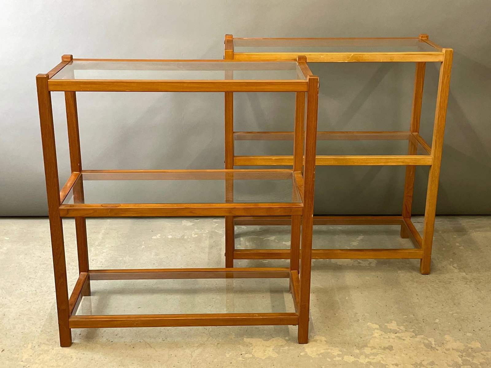 Pair of Danish Teak and Glass Etageres: A pair of Danish teak and glass three-tiered Ã©tagÃ¨res by PBJ Mobler. With foil labels. 34-1/2in tall x 31-1/2in wide x 14in deep.