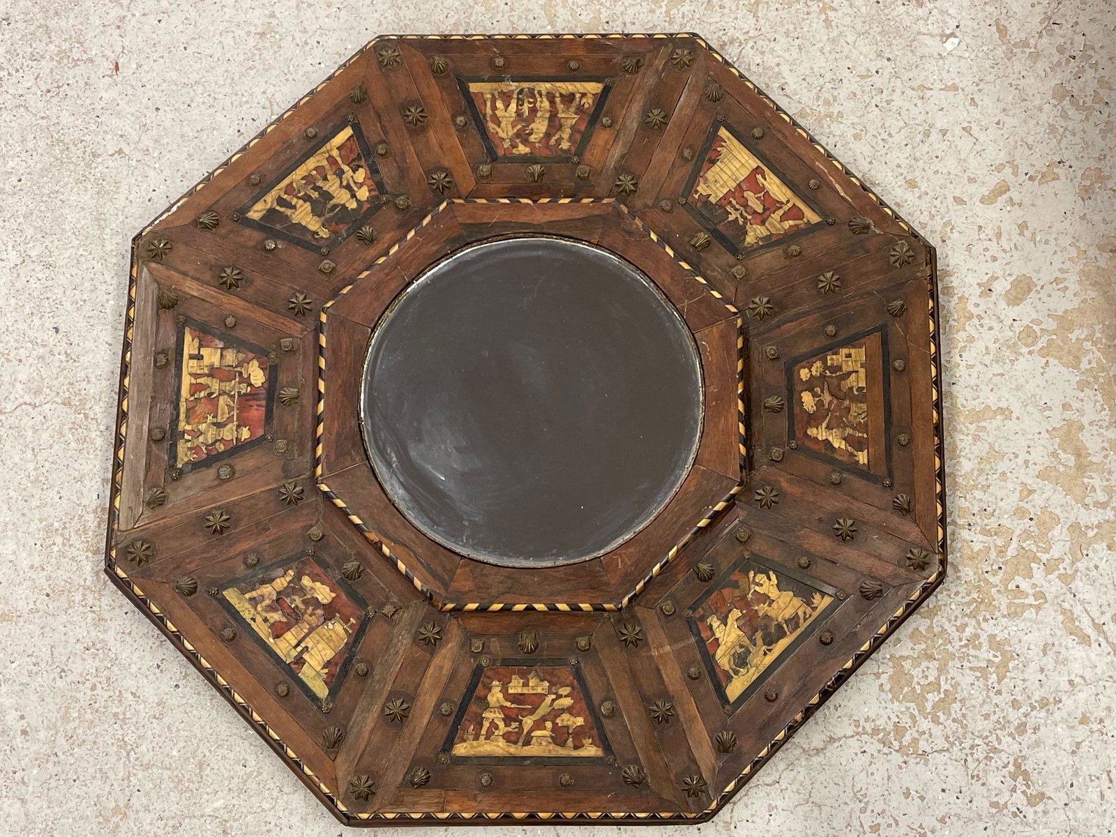 19th C. Persian Mirror: A 19th C. Persian wood-framed mirror converted from an antique card table top, having inlaid bone and stone detail and brass accents, depicting 8 different figural scenes. 33in tall x 33in wide.