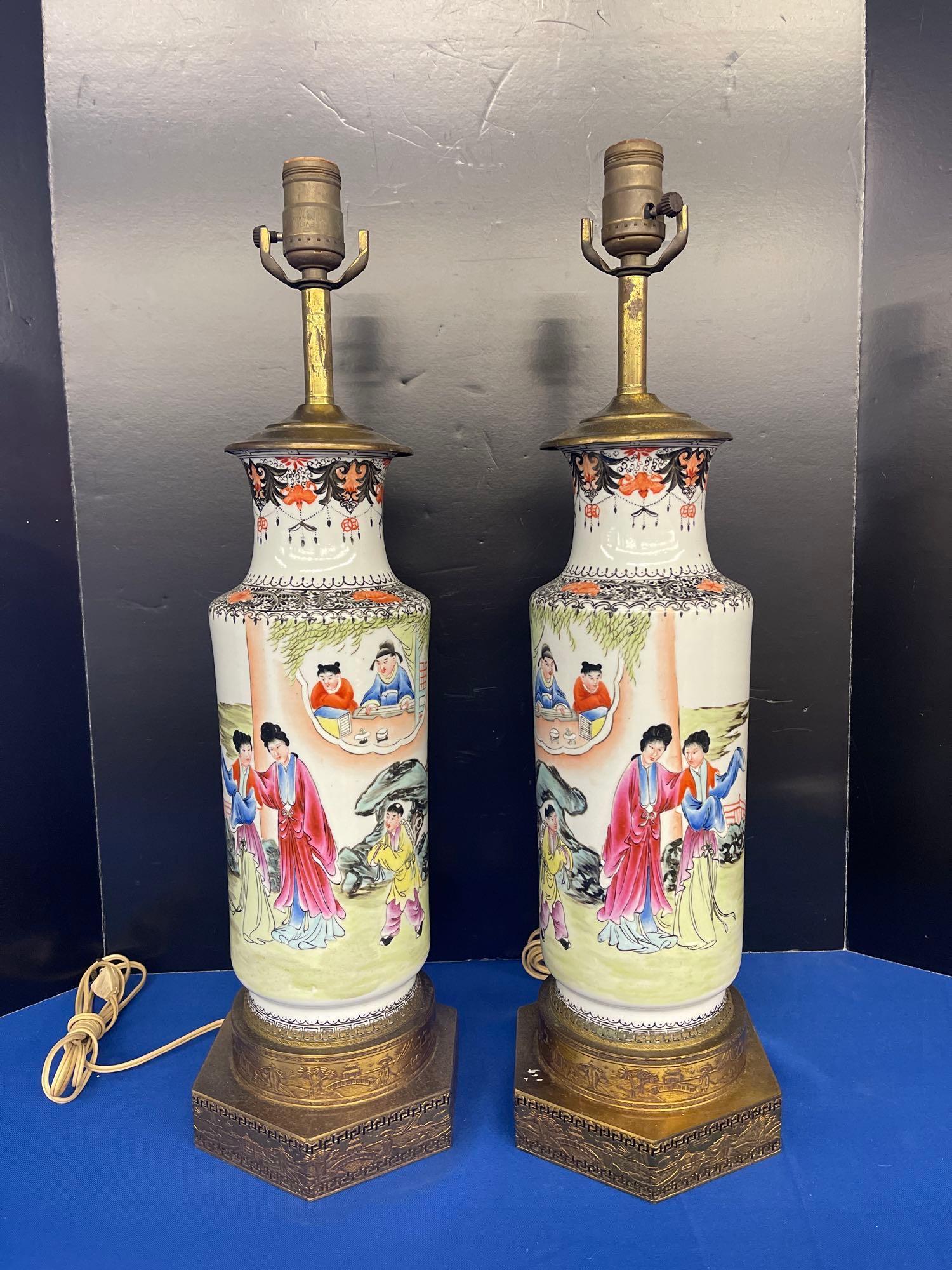 Pair of Chinese Porcelain Lamps: A pair of Chinese porcelain lamps with figural detail, resting on brass bases. 17in tall.
