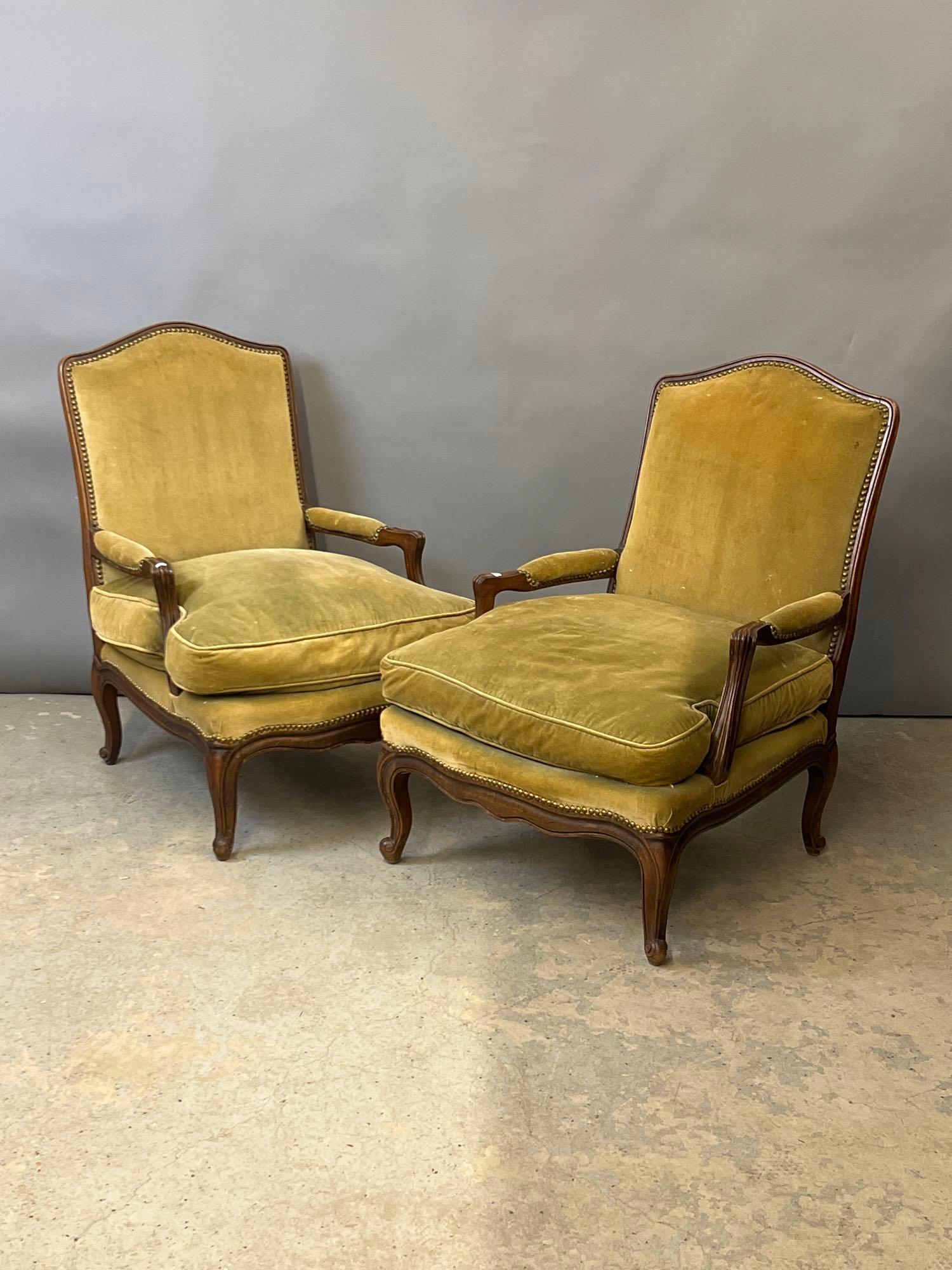 Pair of French Louis XV-style Fauteuils: A pair of French Louis XV-style upholstered fauteuils having brass-tacked trim and carved frames. 37in tall x 27in wide x 27in deep. Seat height: 15in.