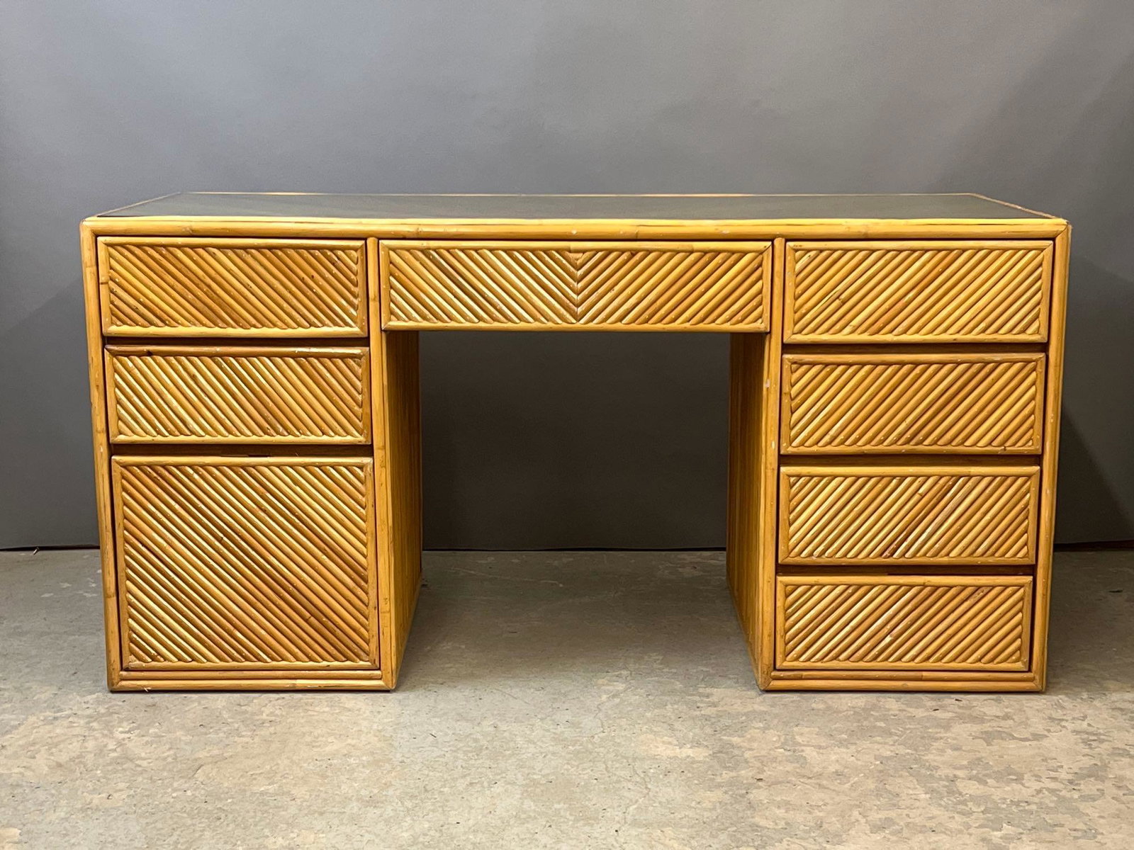 Pencil Reed Bamboo Desk: A pencil Reed bamboo double-pedestal desk with drawers and glass top. 30in tall x 59in wide x 26in deep.