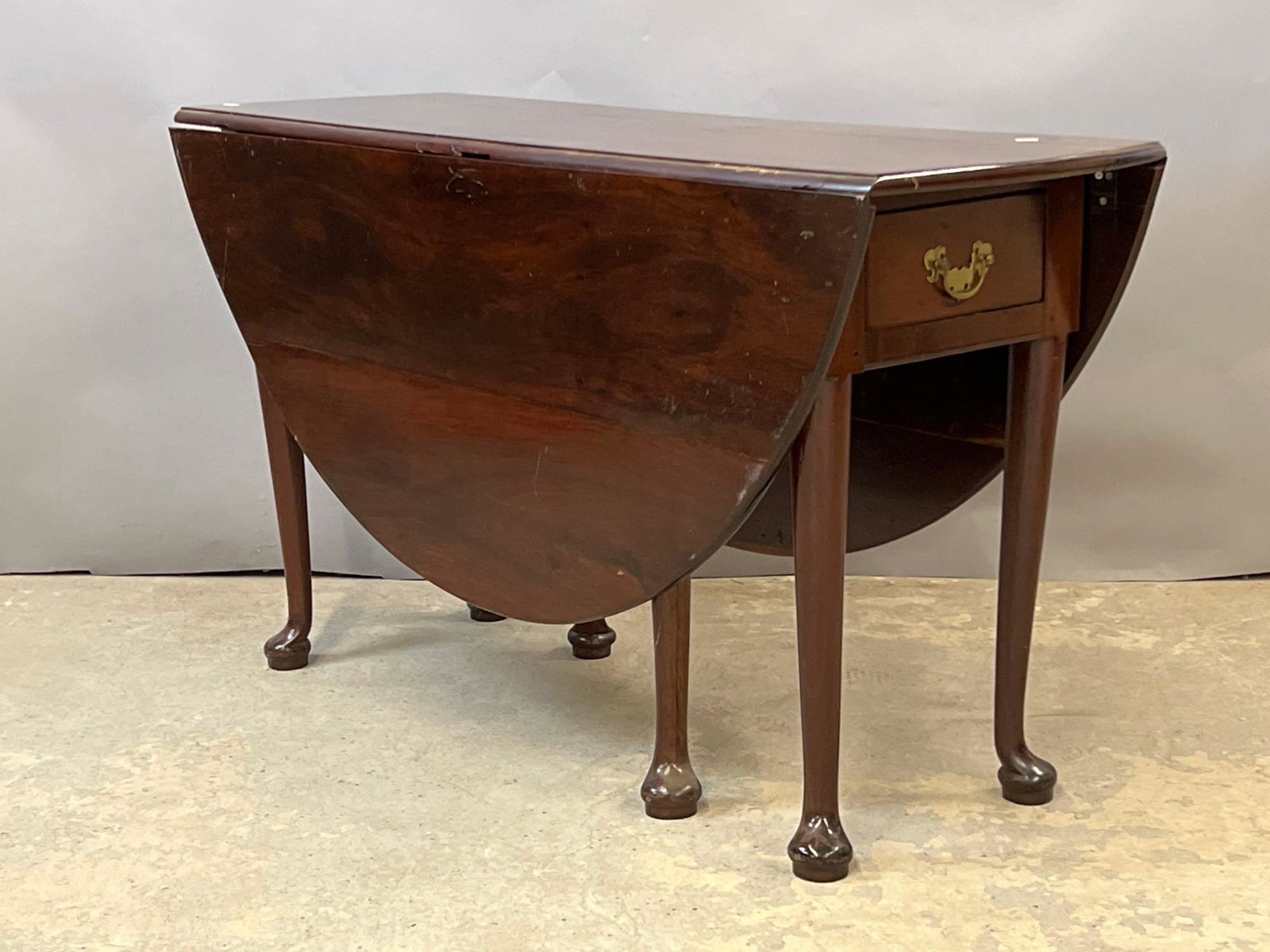 Queen Anne Drop-leaf Dining Table: An 18th C. Queen Anne drop-leaf dining table with single drawer and gate legs. Closed: 28in tall x 48-1/2in long x 17in deep. Each leaf: 20in.
