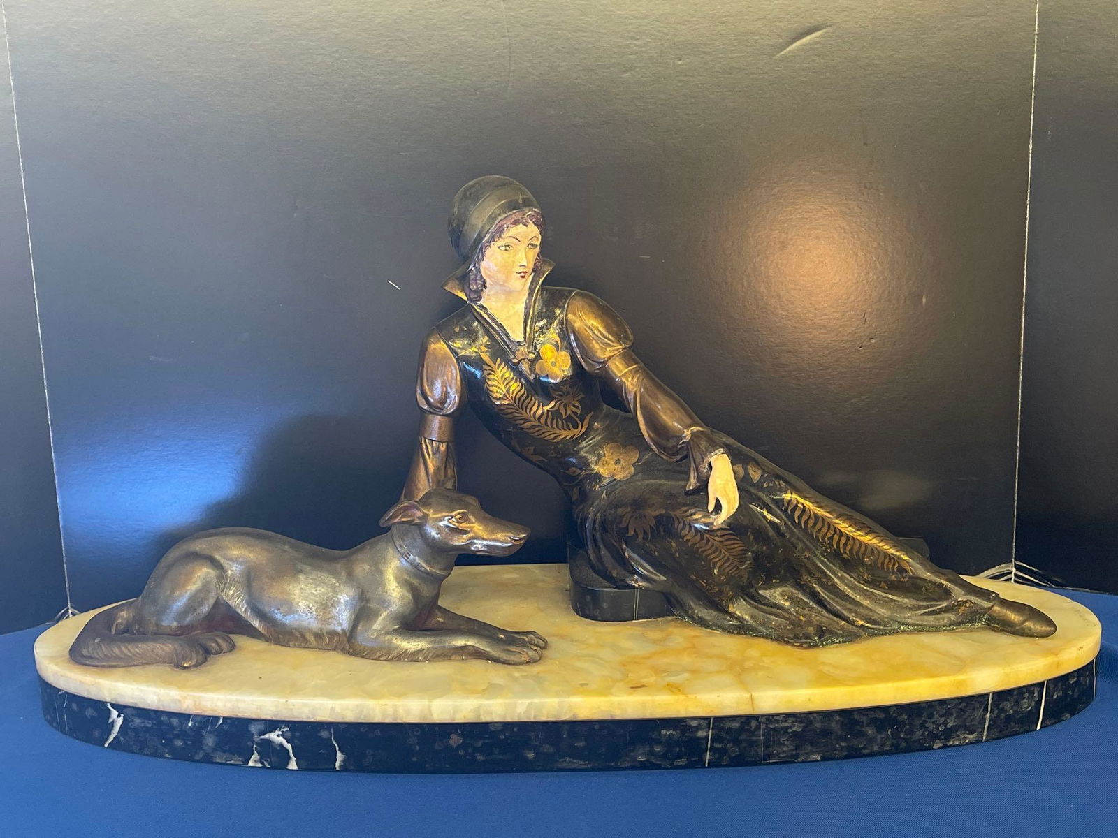 U. Cipriani. Painted Bronze, Woman with Dog: Uriano Cipriani (1880-1930) A bronze figure of woman with hand-painted face and hand seated next to a dog. On marble base. Signed "Cipriani" on marble. 11in tall x 22in wide.