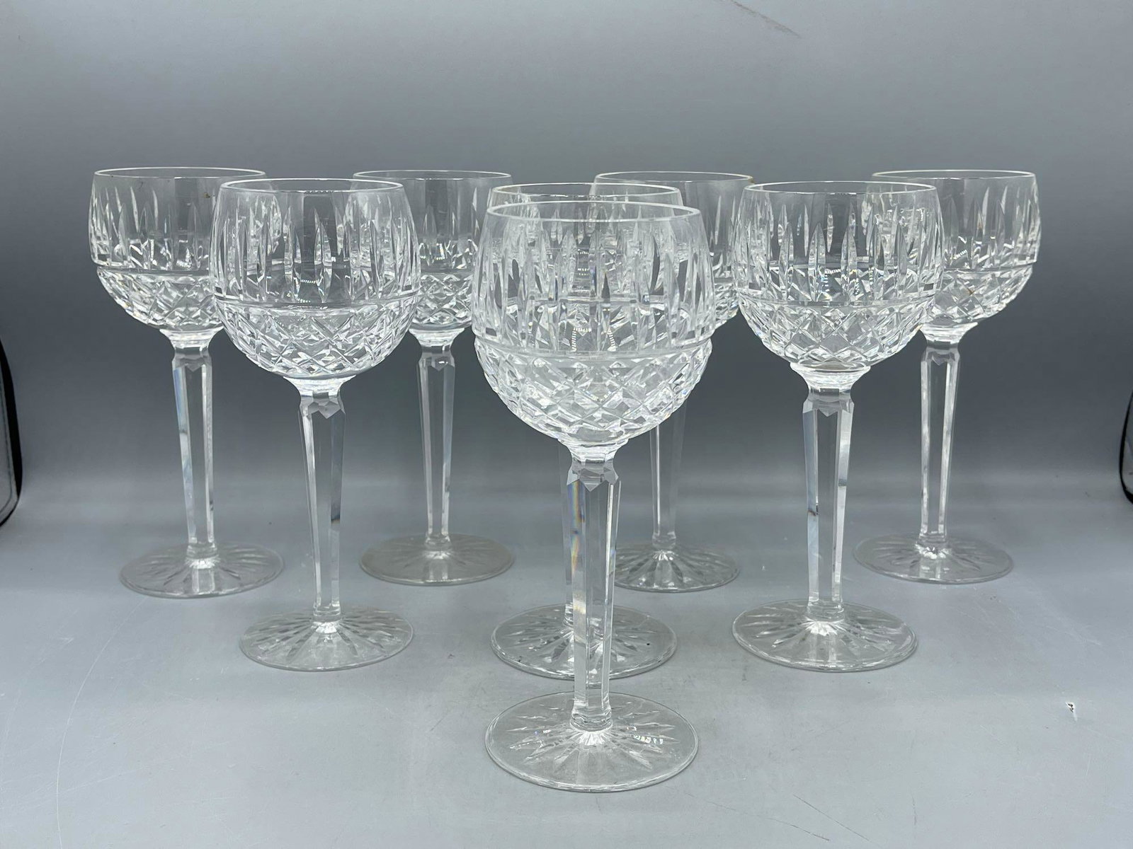 Eight Waterford Crystal Goblets: A set of eight Waterford crystal "Kenmore" pattern wine goblets with cut oval and square detail. Marked "Waterford" underneath. 7-1/2in tall.