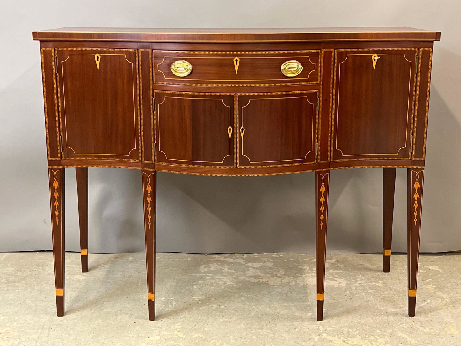 Diminutive Federal-style Mahogany Sideboard: A centennial diminutive Federal-style mahogany sideboard with line and bellflower inlay. 37in tall x 49in wide x 22-1/2in deep. Provenance: From the estate of Ann Dickinson Dale, Princeton, NJ. Key ap