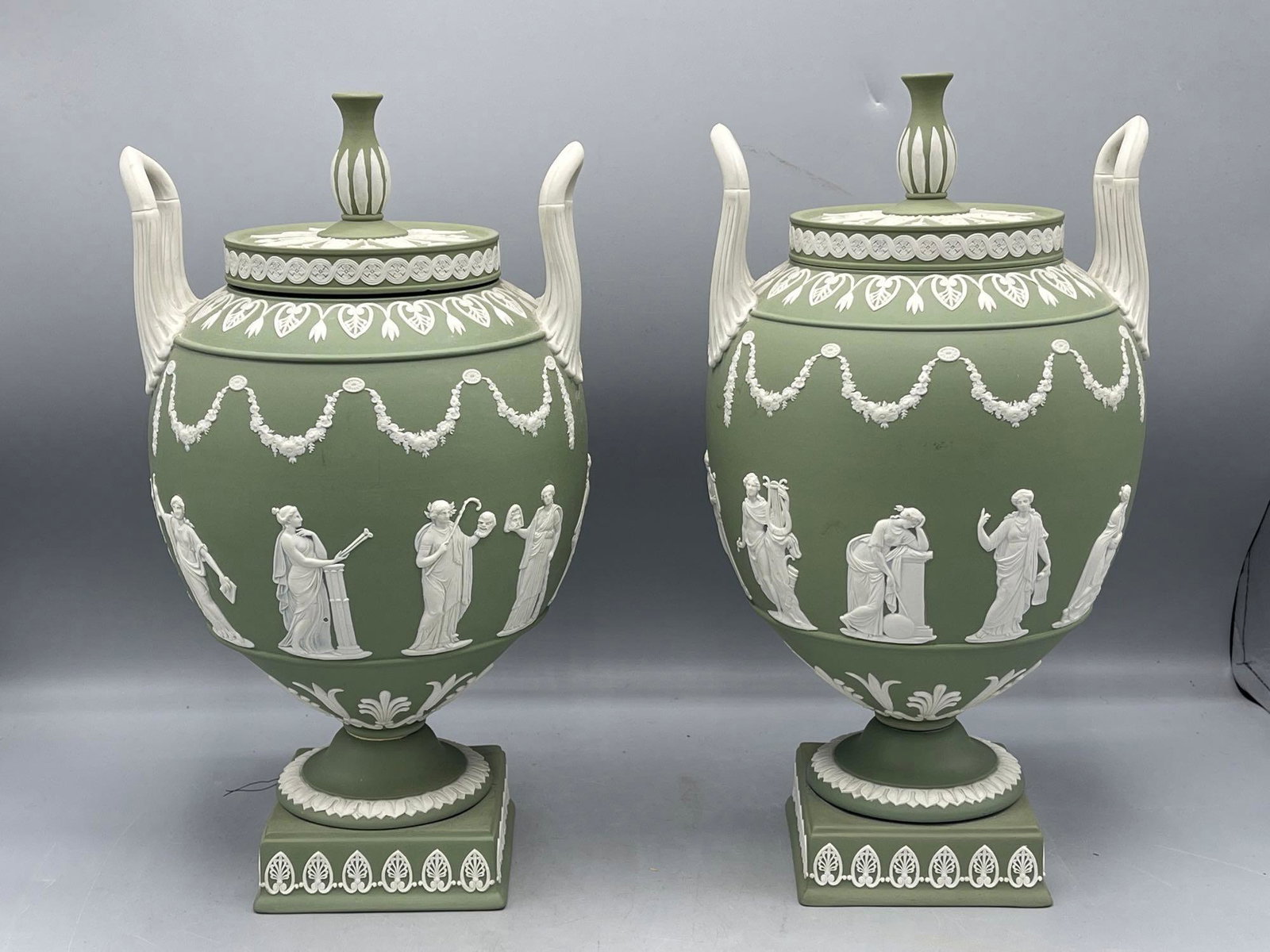 Wedgwood Jasperware Urns: A pair of Wedgwood Jasperware covered urns with Greek motif decoration. 12-1/2in tall x 6in wide.