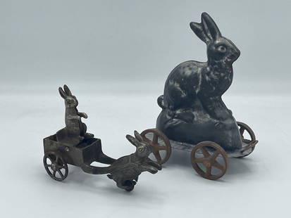 Two Peter Rabbit Pull Toys: To include a Michael Bonne made it metal Peter Rabbit pull toy and a petite cast metal toy depicting rabbits. Larger is 6-1/2 in tall x 5 in wide.