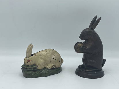 Two Cast Iron Rabbit Banks: To include a hand-painted cast iron rabbit bank with moveable ears, and a bronze standing rabbit bank with moveable ears. Larger is 6 in tall x 3 in wide.