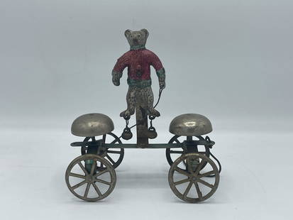 Watrous Toys Teddy Bear Bell Toy: A Watrous Toys cast iron teddy bear bell toy with a petite teddy bear wearing a sweater with dangling bells attached to his feet. 5-1/2 in tall x 5 in wide.