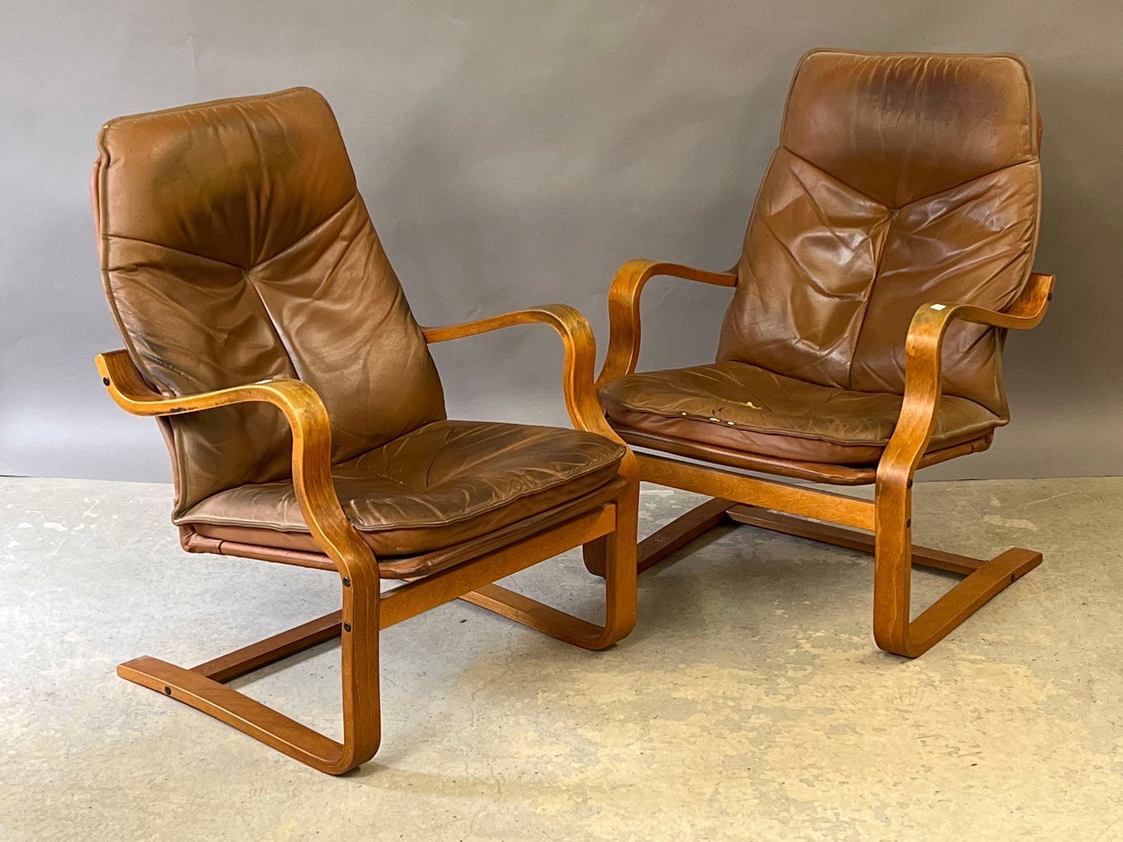 Pair of Modern Design Bentwood Lounge Chairs: A pair of modern design bentwood lounge chairs with leather upholstery. 37in tall x 26in wide x 26in deep. | Local and NYC curbside delivery details and international third-party shipper recommendatio