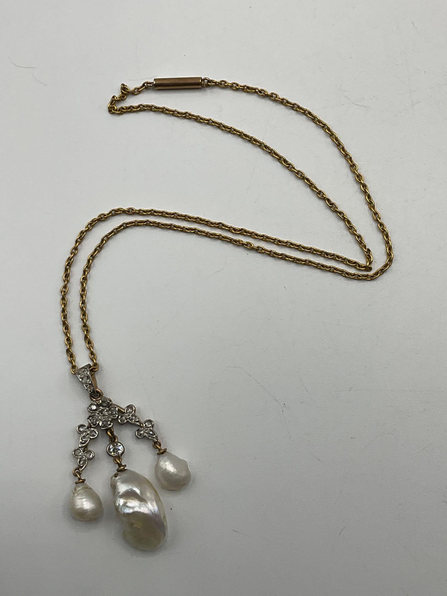 Baroque Pearl and Diamond Necklace: A Baroque pearl and diamond necklace, featuring a removable pearl and diamond floral motif pendant on a tested 14K yellow gold chain. Chain is approx. 14in long; pendant is approx. 1-3/4in long x 3/4i