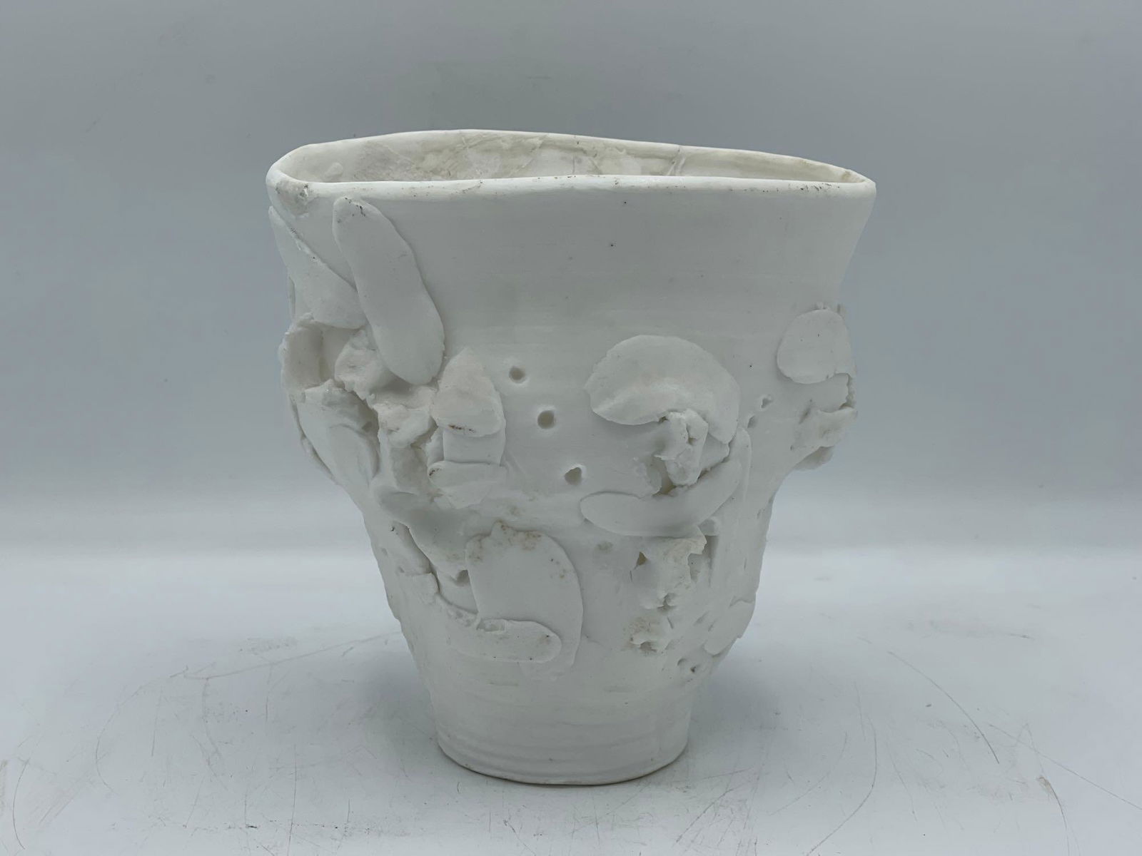 Rudolf Staffel Porcelain Cup: Rudolf Staffel (American, 1911-2012). An abstract and delicate hand-built porcelain cup with tall relief decoration. The translucent porcelain and perforations allow light to shine through. Many of th
