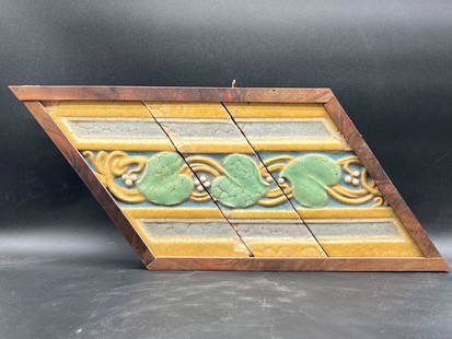 Three Grueby Faience Company Tiles: Grouping of three Grueby Faience Company vine leaf glazed ceramic tiles in a wooden frame. Outside frame: 10-3/4in tall x 24in wide. Provenance: Chestnut Hill Arts & Crafts private collection. | Local