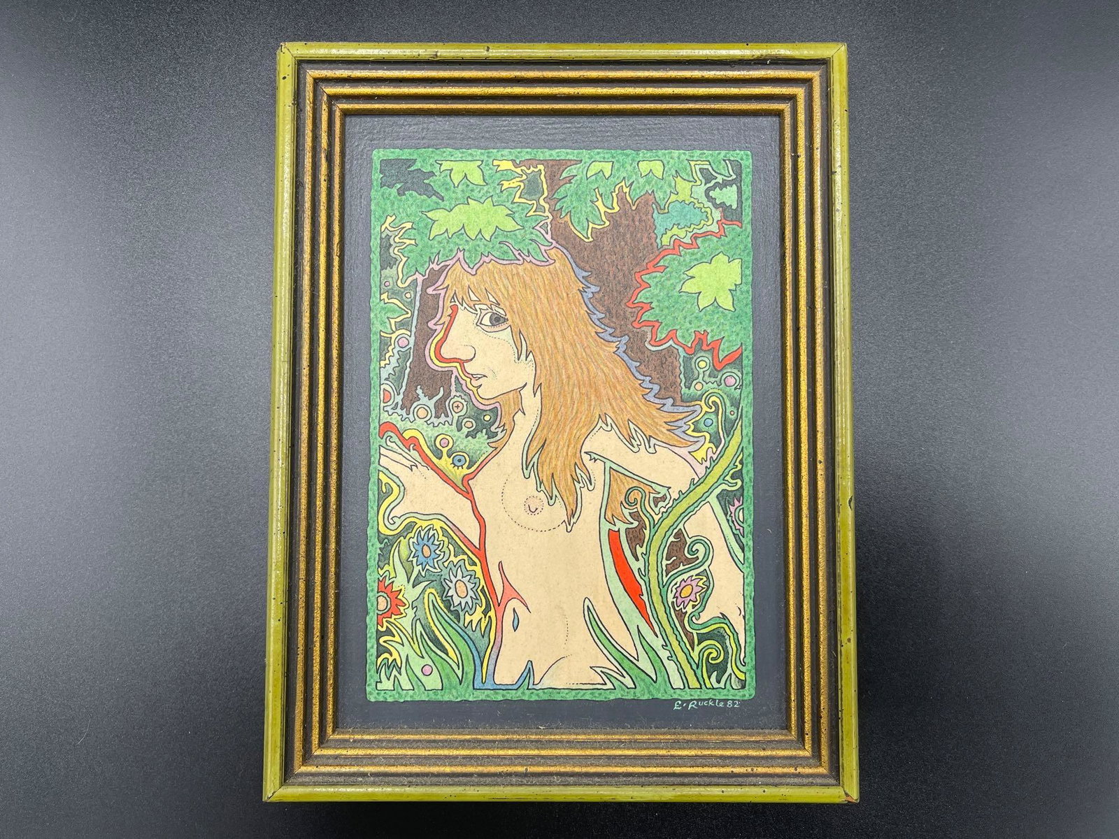 Ernest Ruckle. Acrylic/Board Female Nude: Ernest Ruckle (American, b. 1945). An acrylic on board titled "In the Woods", depicting a female nude in colorful forest. Signed E. Ruckle 82 lower right. Attributed and titled en verso. Board: 7in x 
