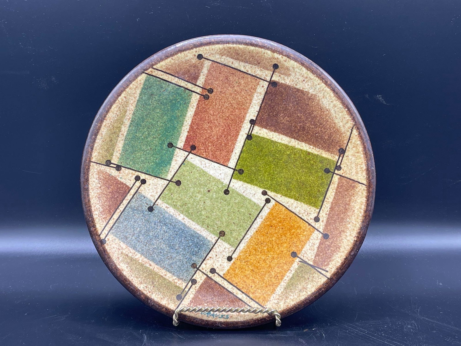 Myrton Purkiss Stoneware Plate: Myrton Purkiss (American, 20th C.). A stoneware plate with geometric colorful design, signed M. Purkiss on back and Purkiss at bottom of plate. 8-1/2in diameter. Provenance: Chestnut Hill Arts & Craft