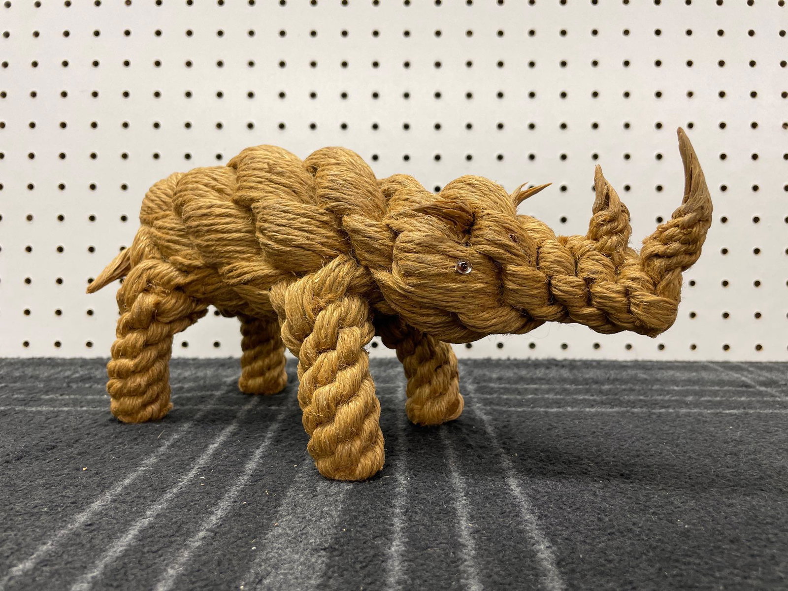 Rope Woven Folk Art Rhinoceros Sculpture: (A) A whimsical folk art style rhinoceros sculpture made of woven twine. In excellent with no significant damage. Measures 12in long x 4 1/2in wide x 6in tall. | Please read the Terms for local pickup
