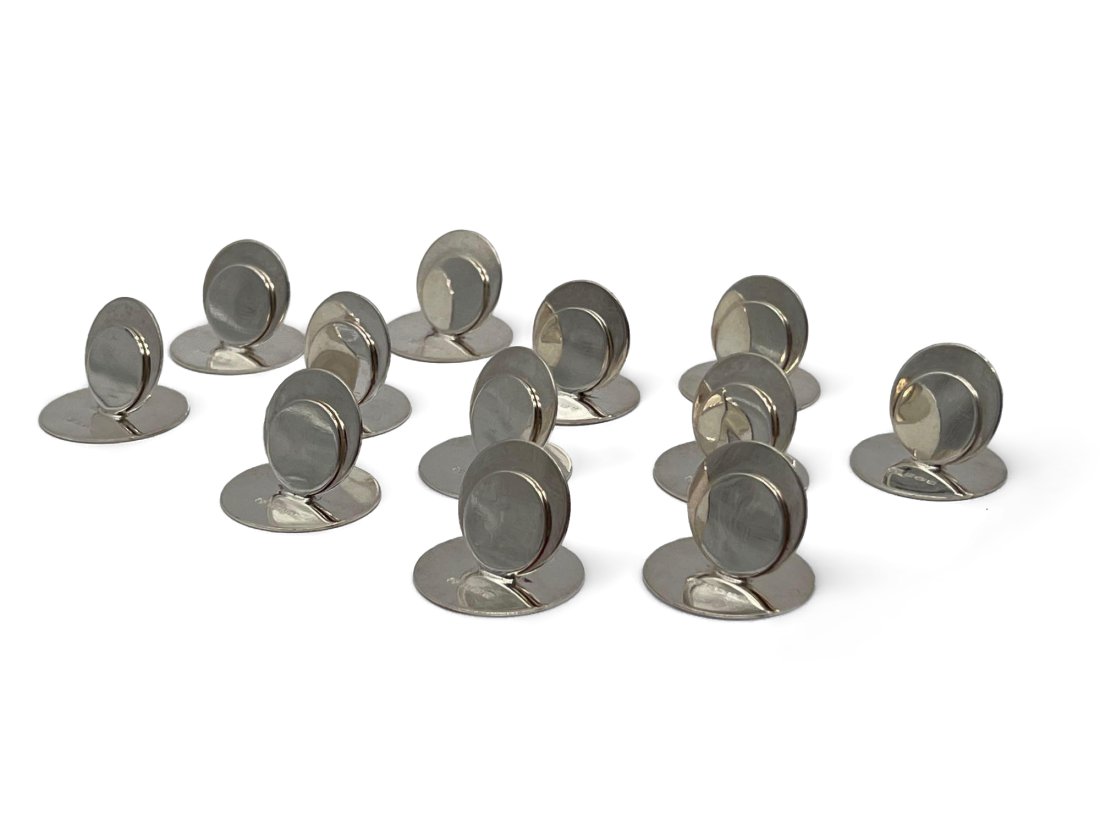 Twelve Modernist Sterling Place Card Holders: A set of twelve English modernist sterling silver place card holders, each hallmarked AMW. 1in tall x 1-1/4in wide. 5.1 ozt. | Philadelphia Metro area and NYC curbside delivery details, and internatio