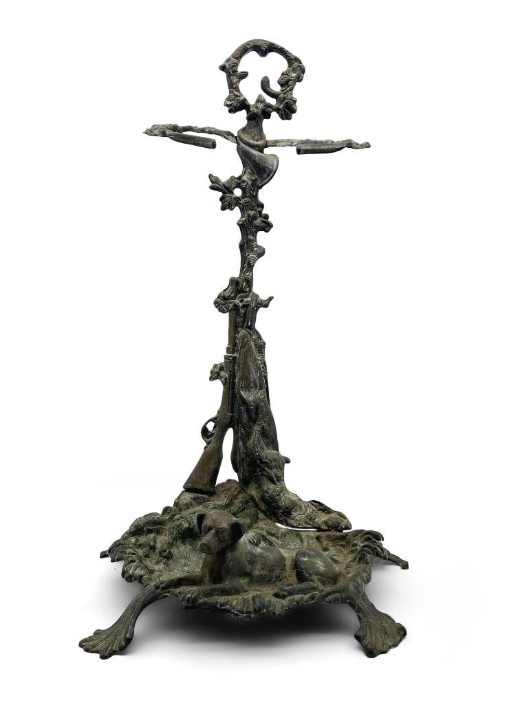Bronze Hunting Scene Umbrella/Cane Stand: A bronze umbrella or cane stand with hunting scene with seated dog and shot gun. 21-1/2in tall x 11-1/2in wide. | Philadelphia Metro area delivery, NYC curbside delivery, and international third-party
