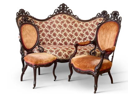 Three-Piece Victorian Rosewood Laminate Parlor Suite: A three-piece Victorian rosewood laminated parlor suite attributed to John Belter, comprised of a sofa, armchair, and side chair, each with pierced and carved foliate crests. Sofa: 48in tall x 68in wi