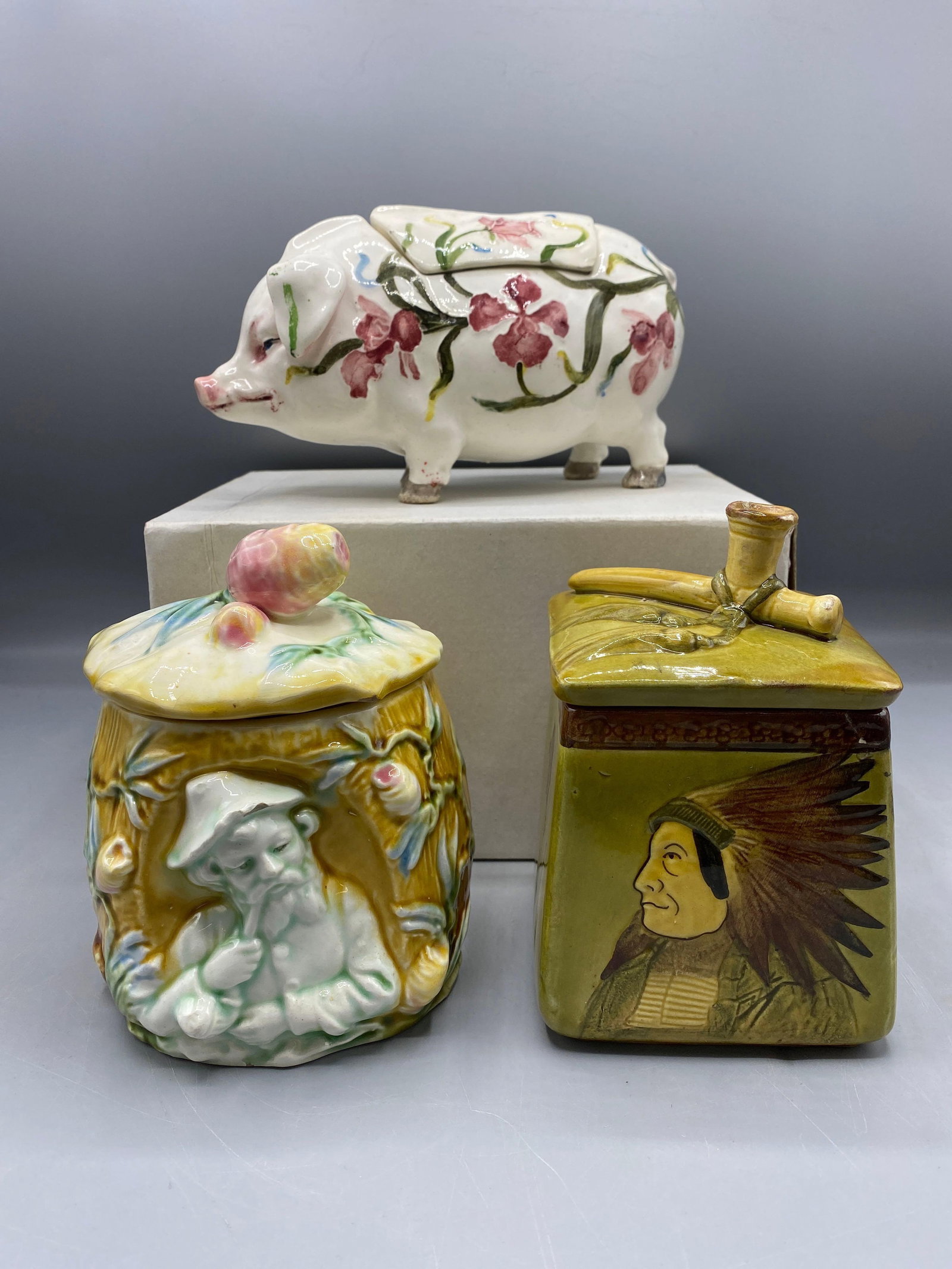 Three Majolica Tobacco Jars: To include a pig (7-1/2in wide), and a Native American and figural tobacco jar, each 6in tall. | Philadelphia Metro area delivery, NYC curbside delivery, and international third-party shipper informat